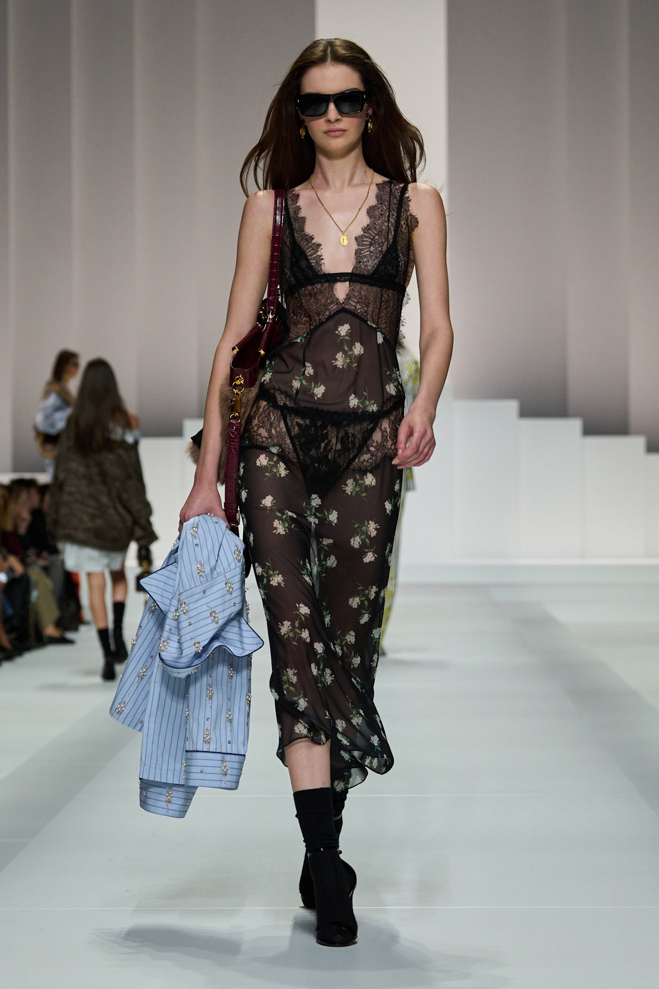 A model wears a long sheer black floral dress.