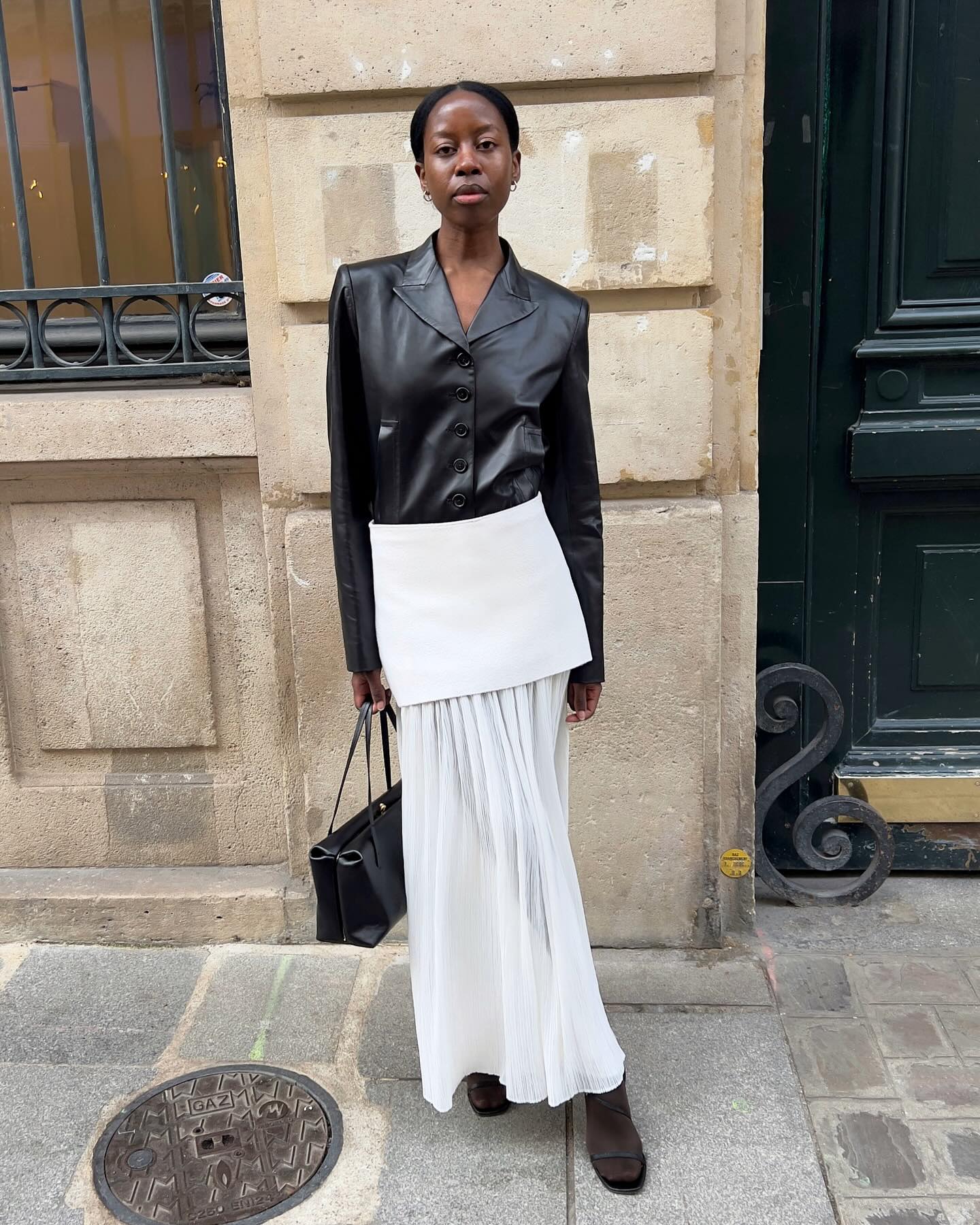 An image of French influencer @sylviemus_ wearing a tiered sheer skirt, one of the biggest skirt trends, with a black leather jacket.