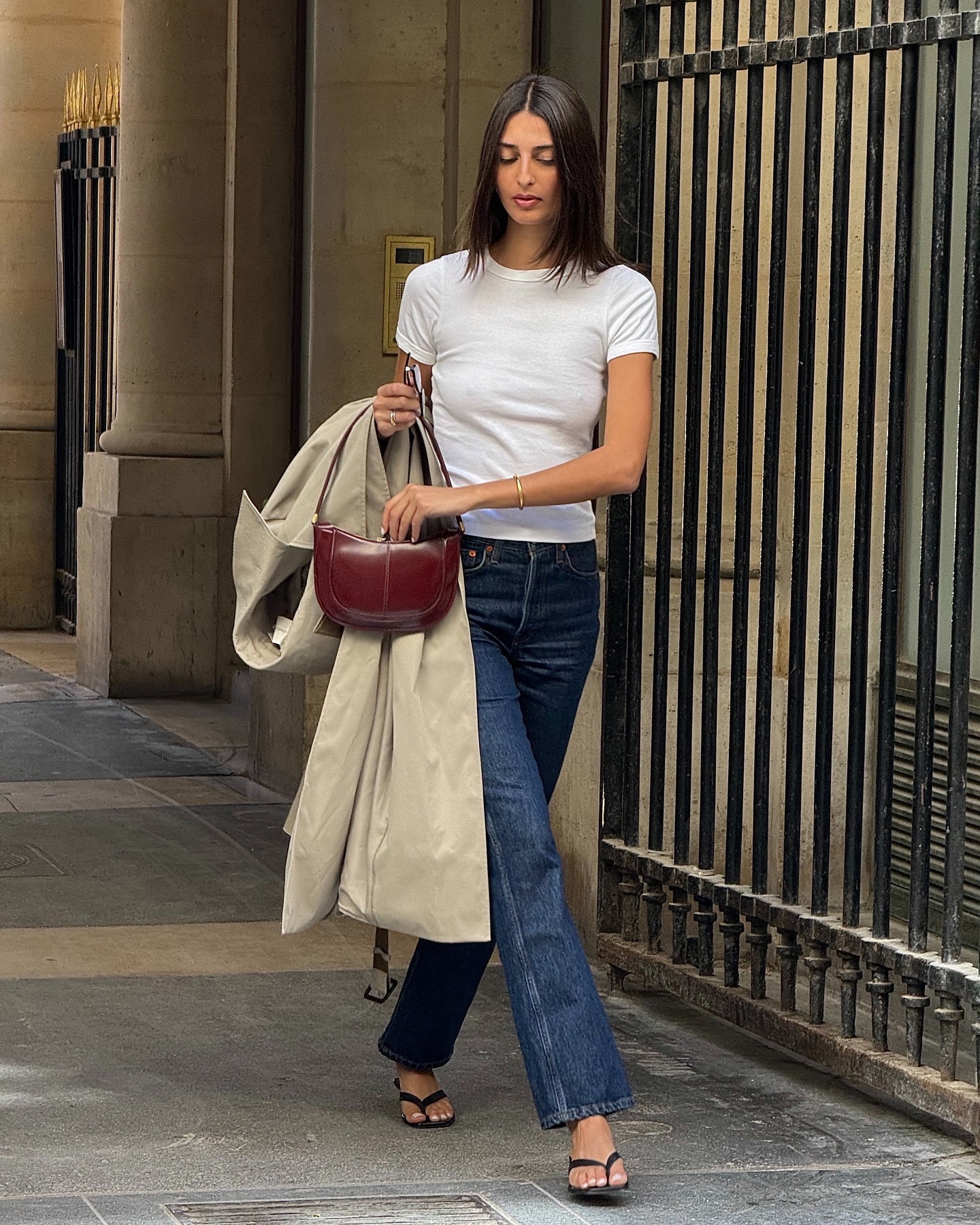 Woman in white t-shirt and dark straight-leg jeans.