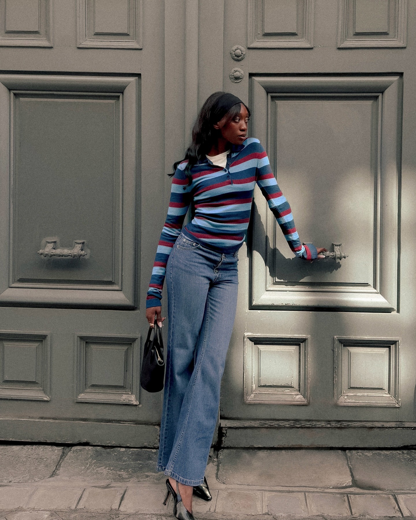 Woman in striped polo and jeans.
