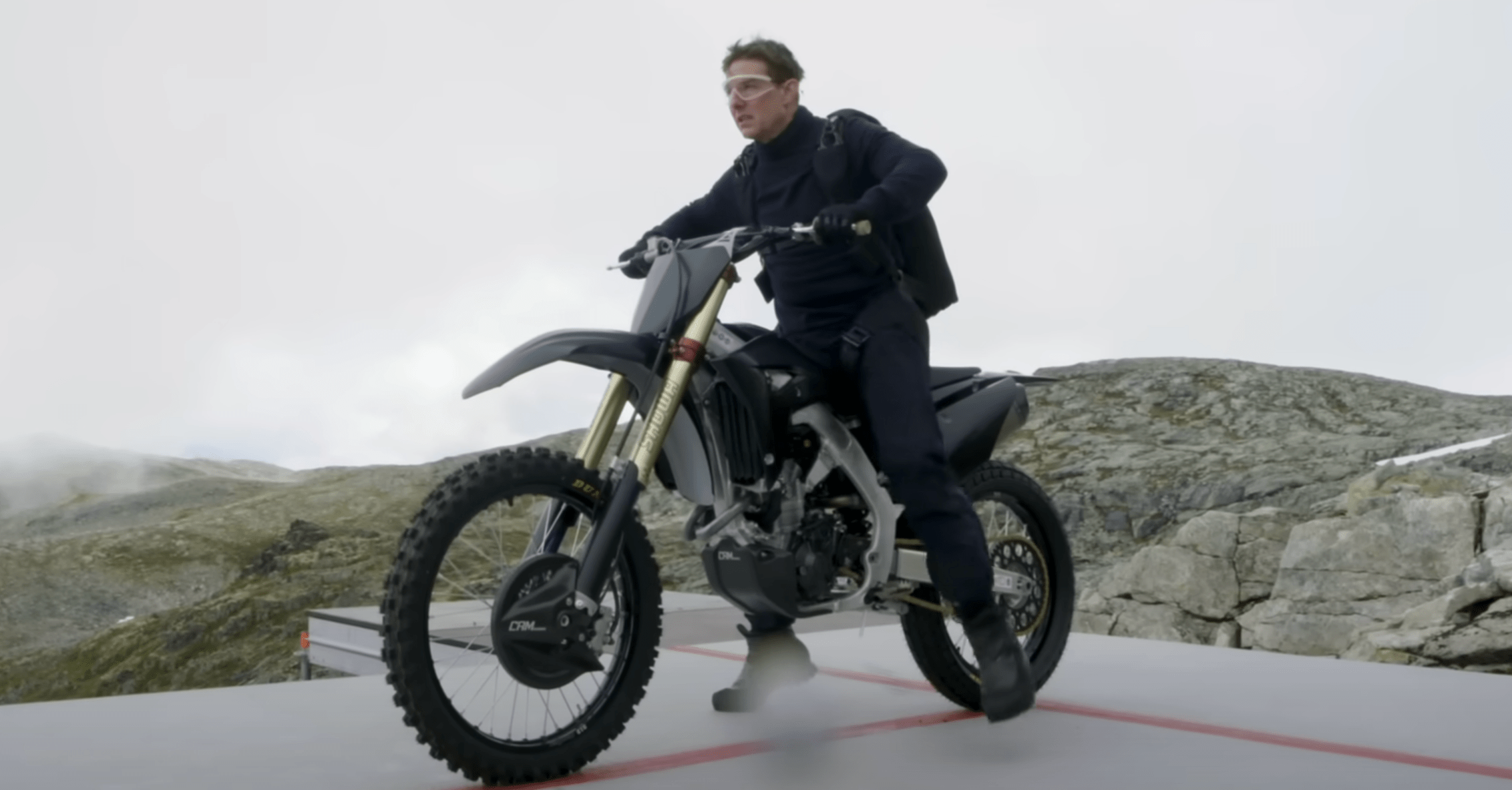 Tom Cruise straddling a motorcycle on the set of Mission: Impossible - Dead Reckoning Part One.