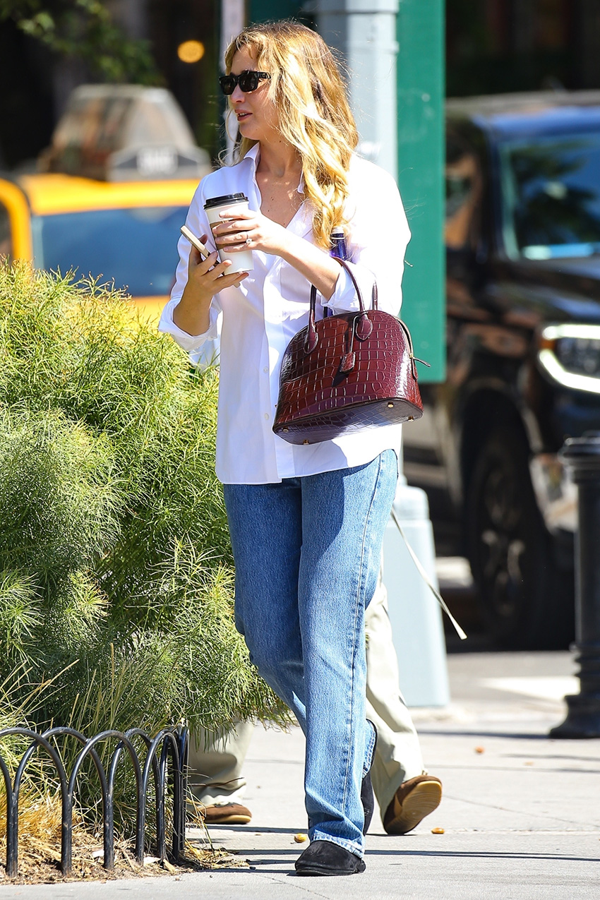 Jennifer Lawrence wearing a white button-down, jeans, black flats, and a burgundy croc-embossed bag in NYC