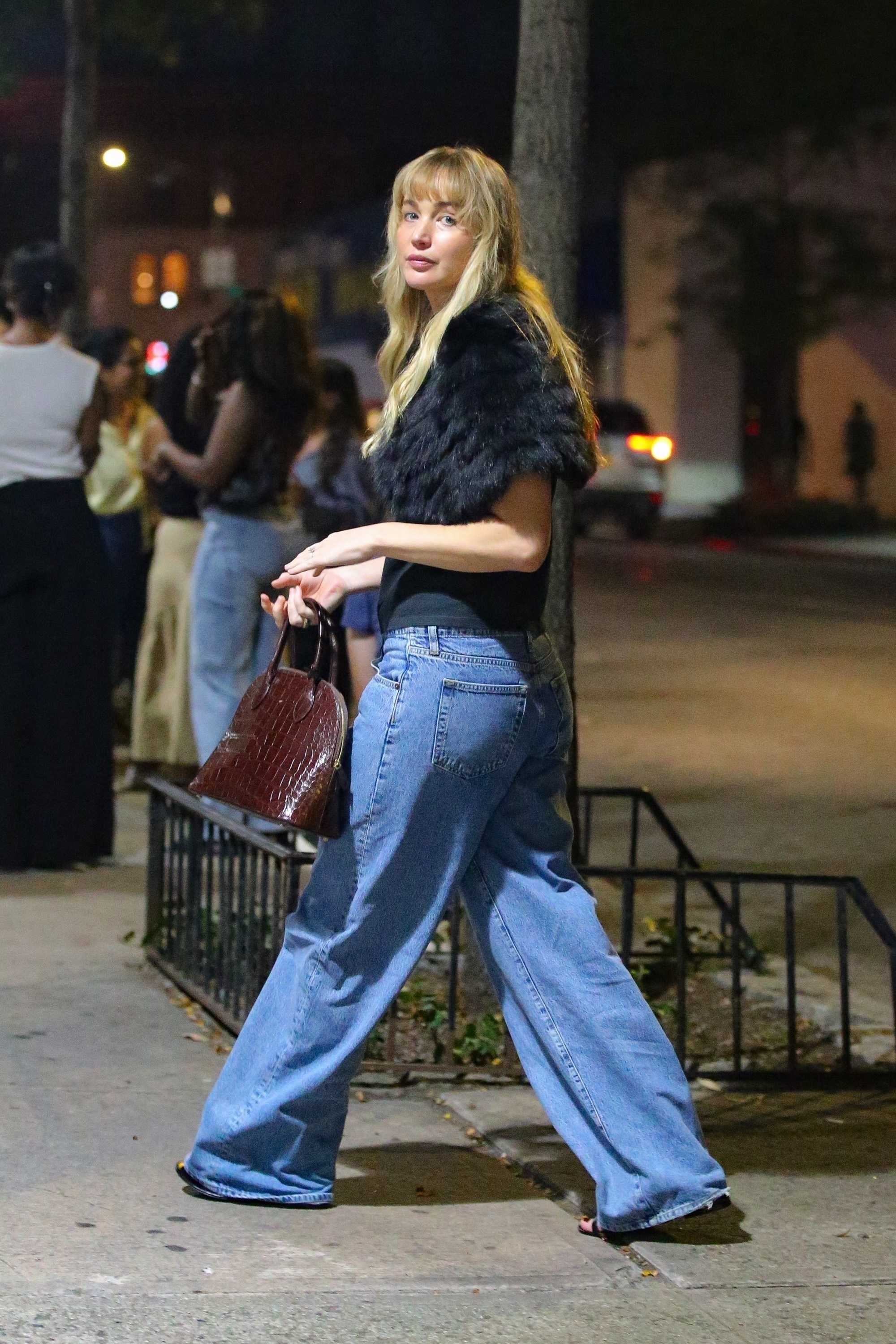 Jennifer Lawrence is spotted out and about in New York, wearing a black t-shirt and jeans and accessorizing it with black fur and a red leather bag.