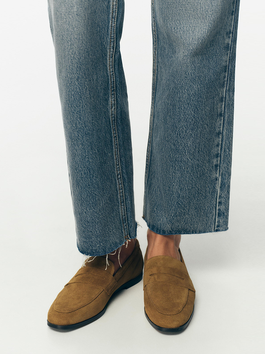 Zara product shot featuring a model wearing raw-hem jeans and tan suede split leather loafers