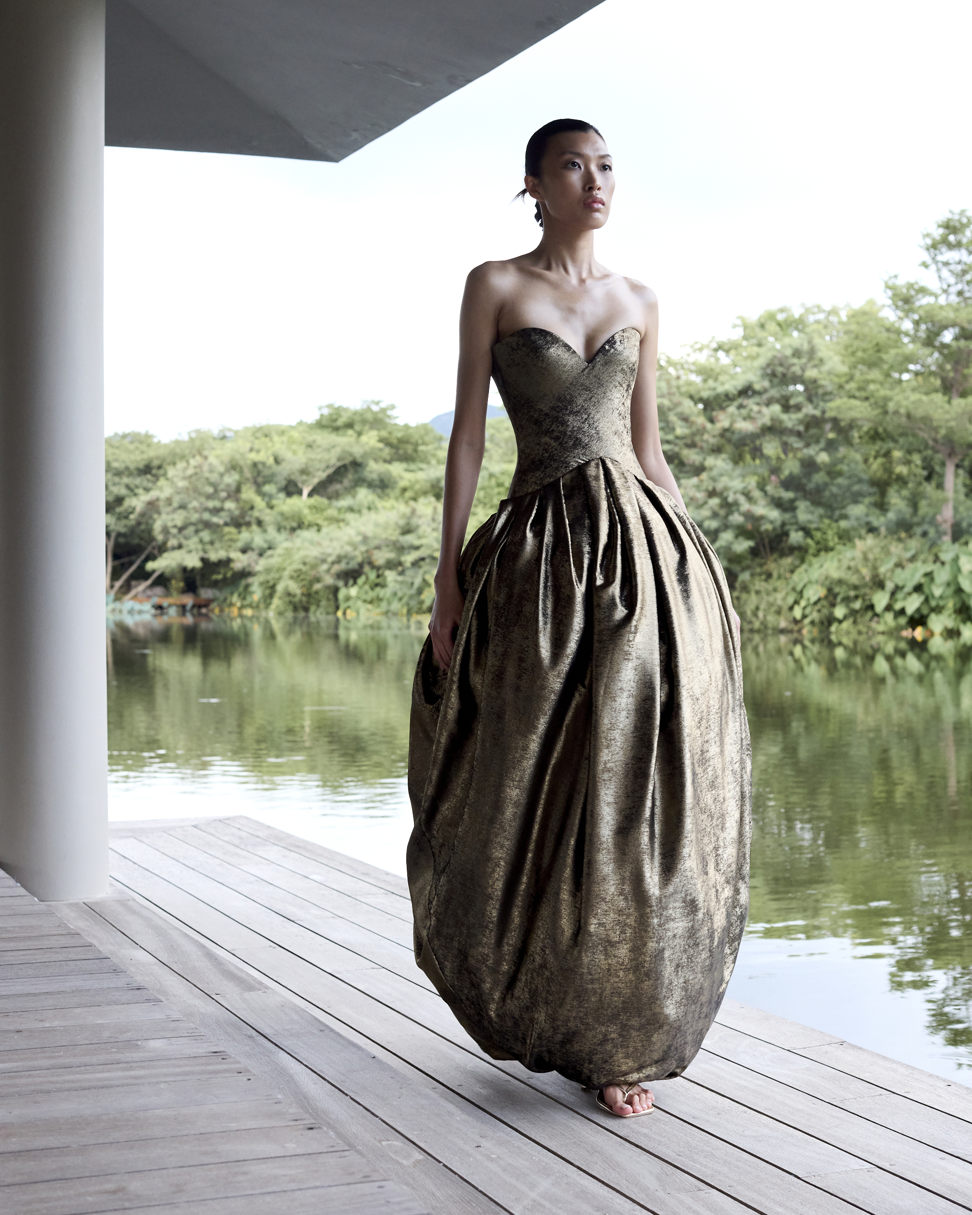 A woman wears a reverse-v-waistline gown in gold.