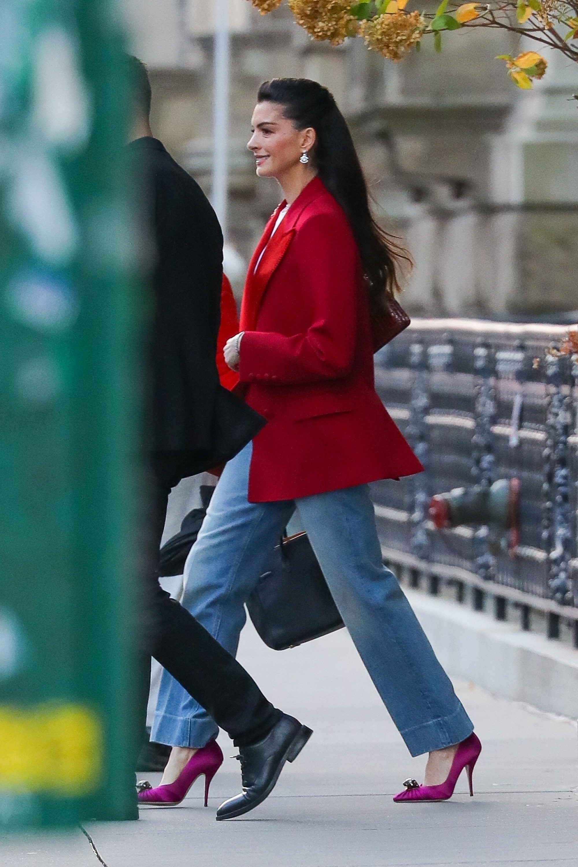 Anne Hathaway wears a red blazer and jeans