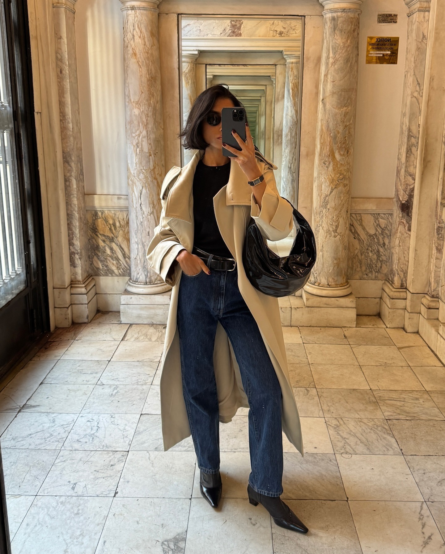 An influencer wears a long coat with jeans and heeled sock boots.