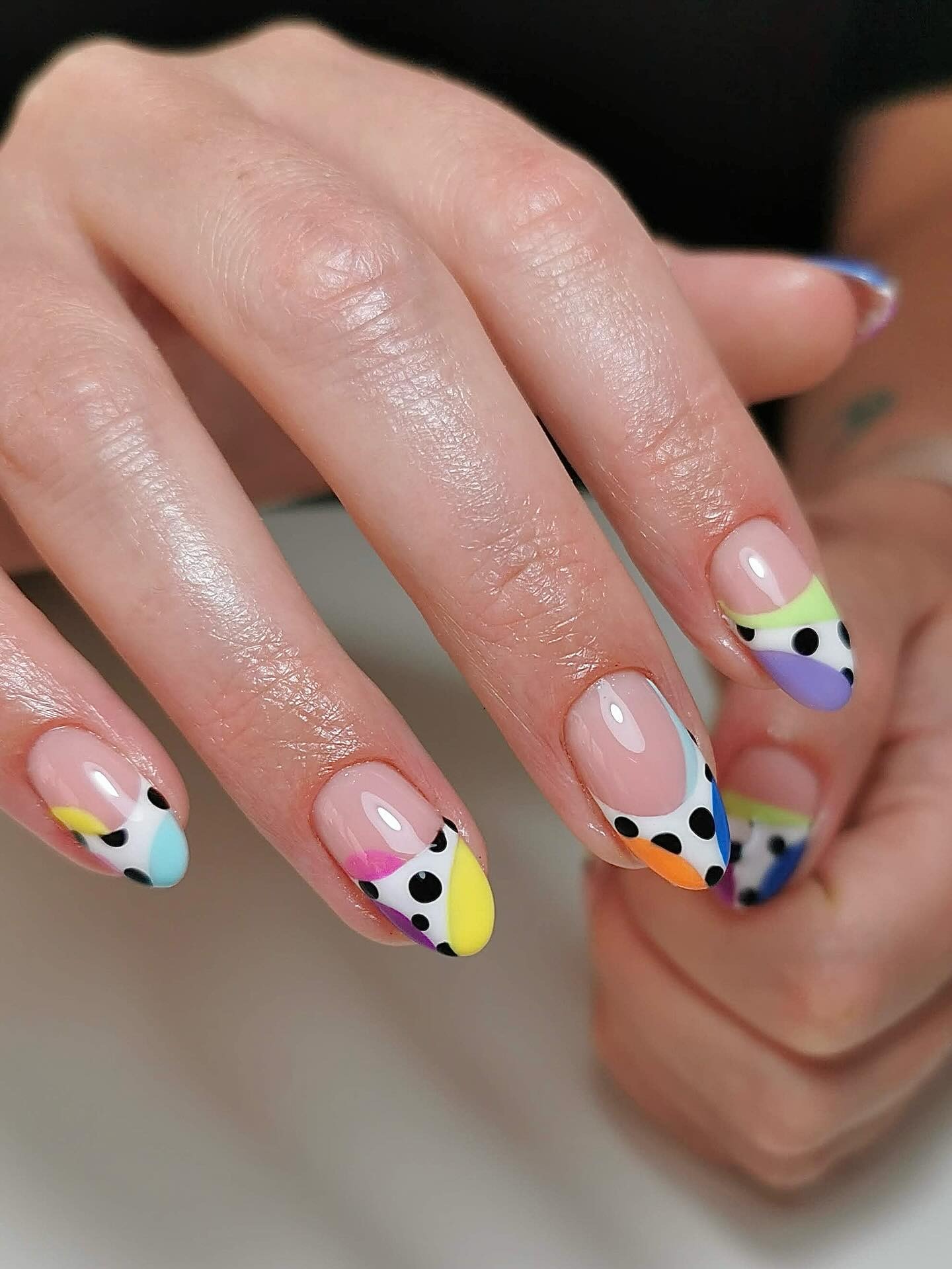 A colourful polka dot French tip nail design