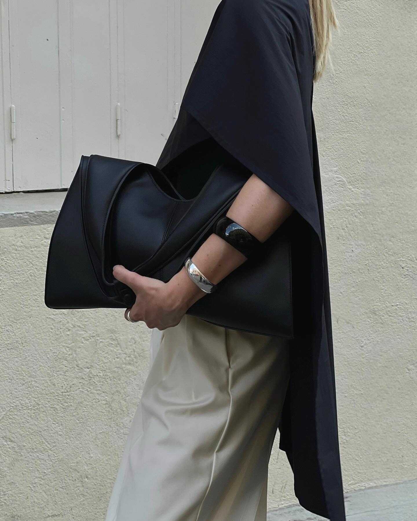 Influencer @signeemilieolesen wears a black satin blouse with cream satin trousers.