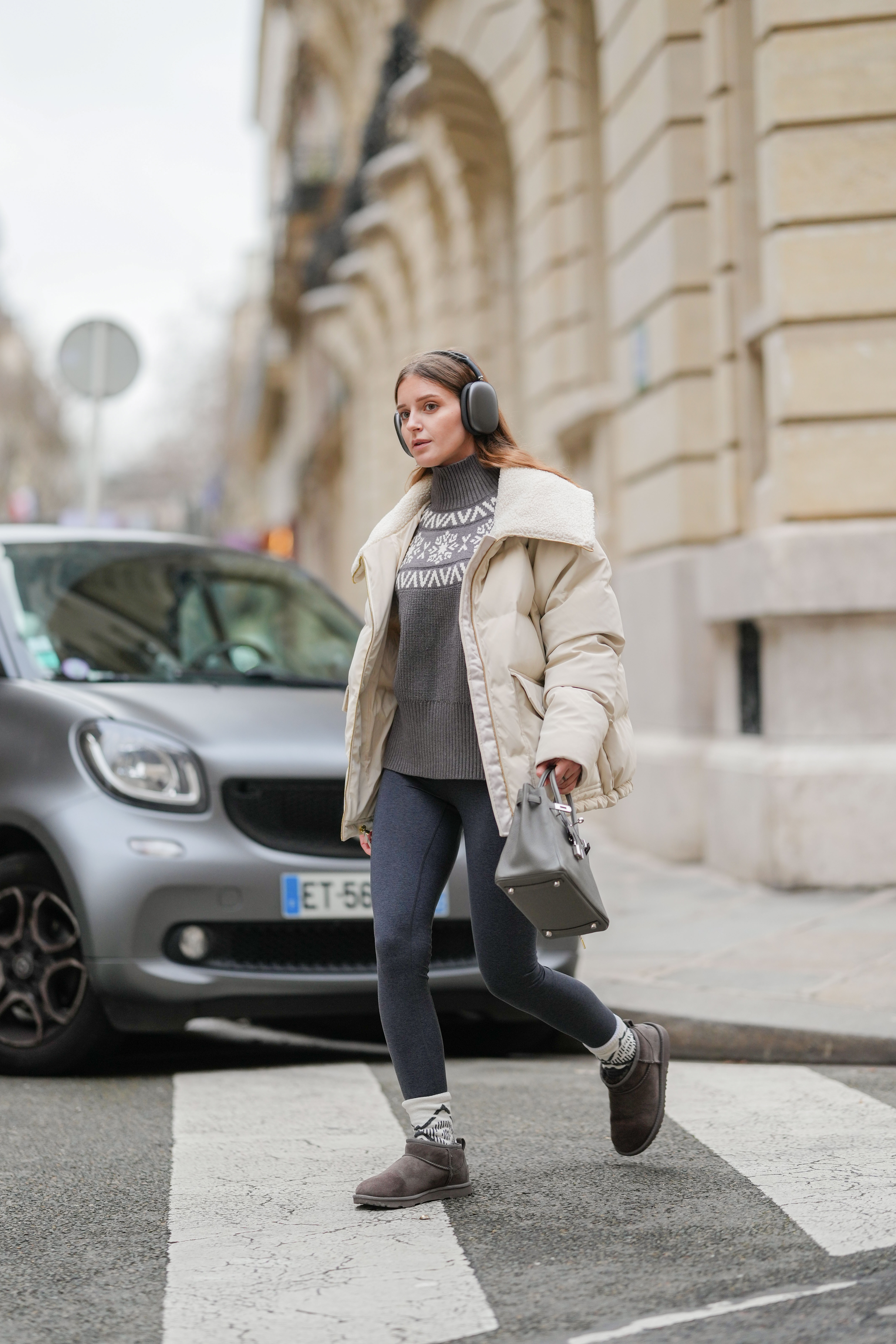 Diane Batoukina wears a gray and white sweater, gray legging, and Uggs.