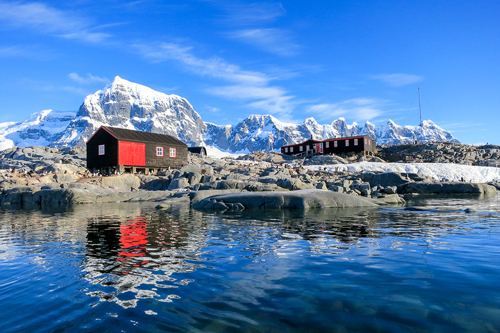A mountainous scene showing three huts in Antarctica where Peter will be counting penguin