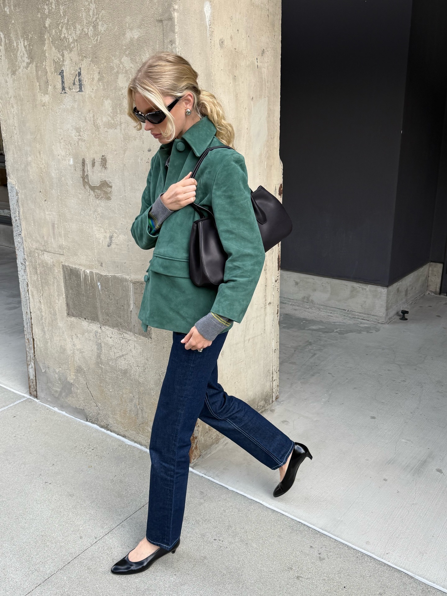 Model Elsa Hosk wears a dark green suede jacket with straight-leg jeans and heeled ballet pumps.