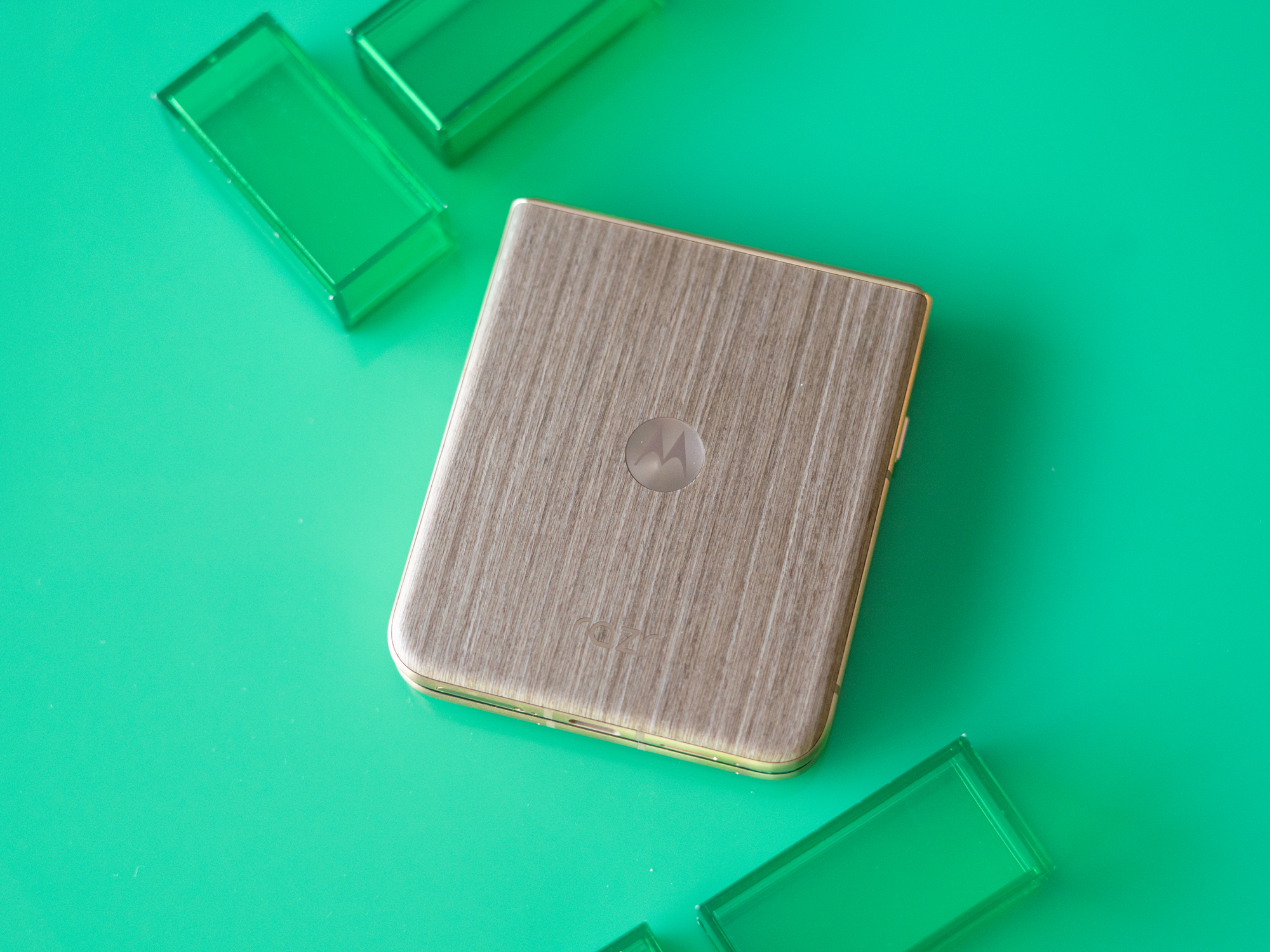 Motorola Razr Ultra on a green background showing wooden back panel