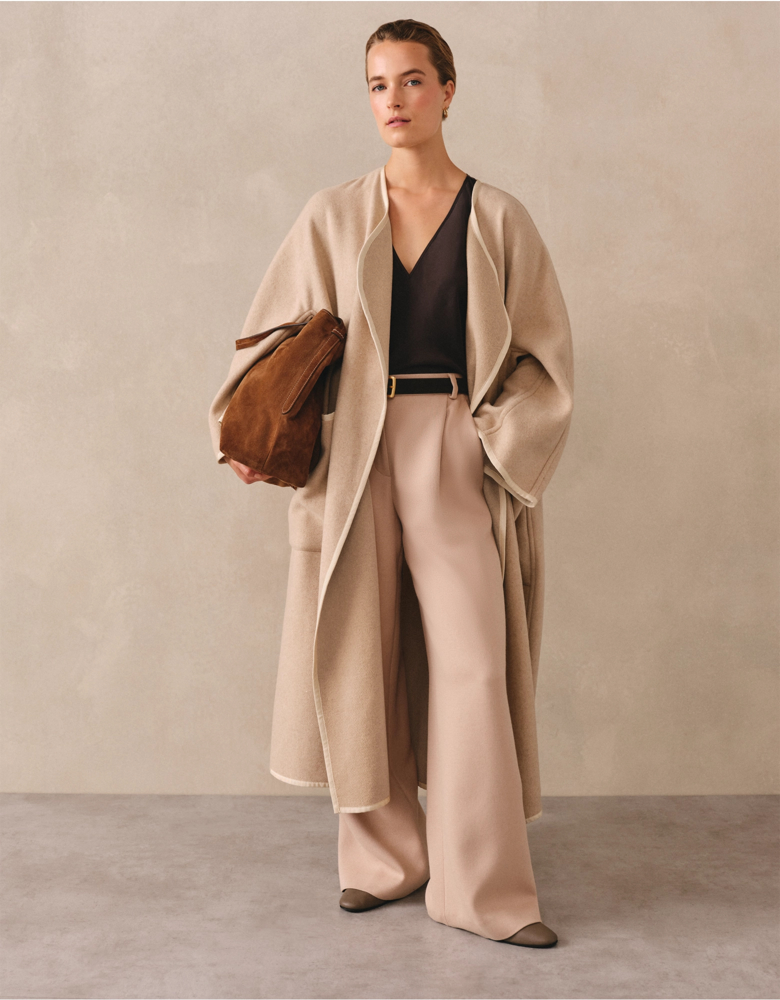 A woman wears a cream wool White Company coat