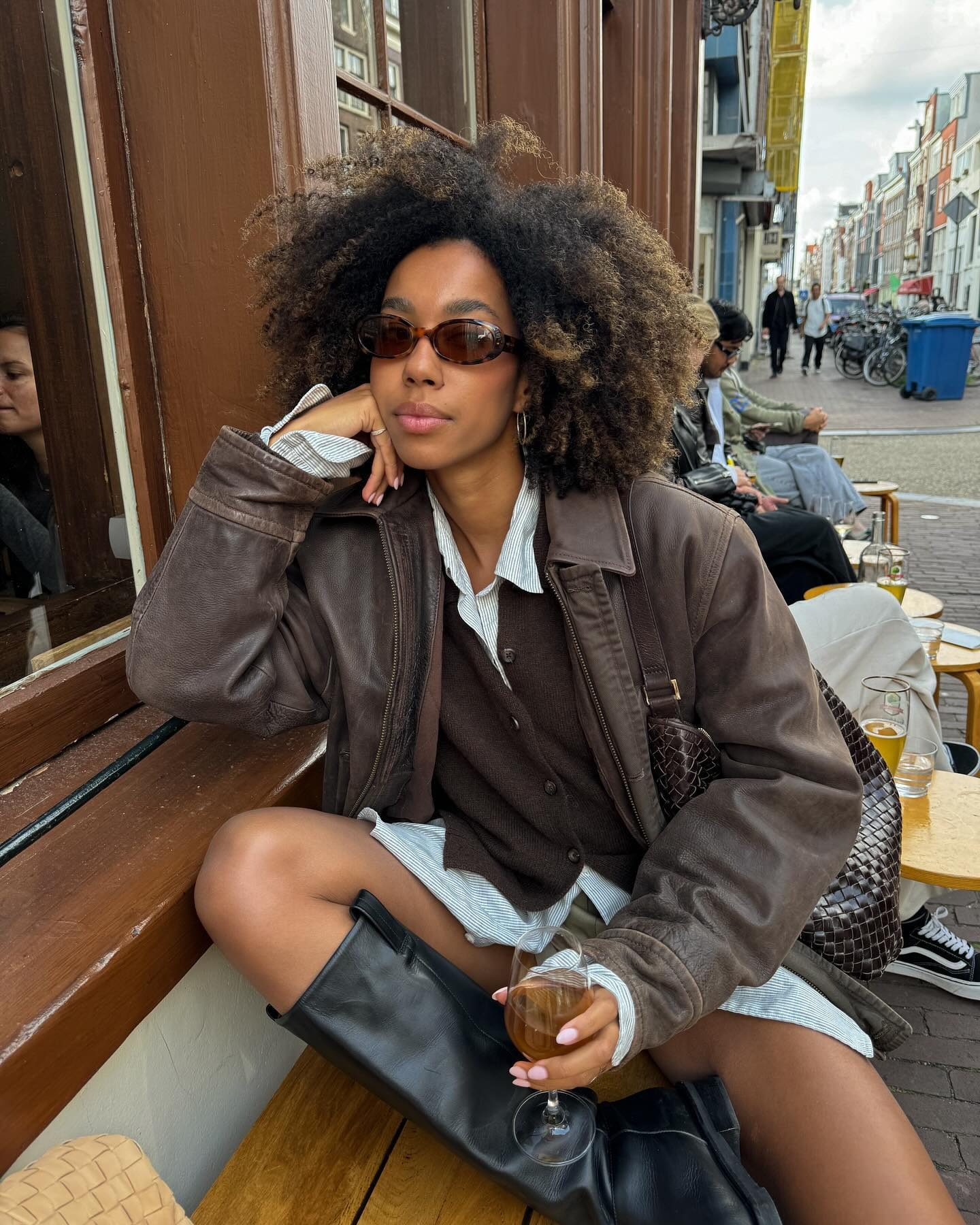 Influencer @amaka.hamelijnck wears a brown cardigan with a brown leather jacket and black boots.