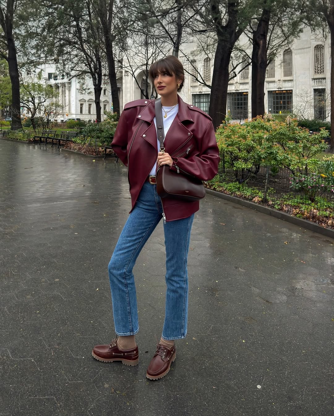 @juliesfi wearing a burgundy leather jacket and jeans
