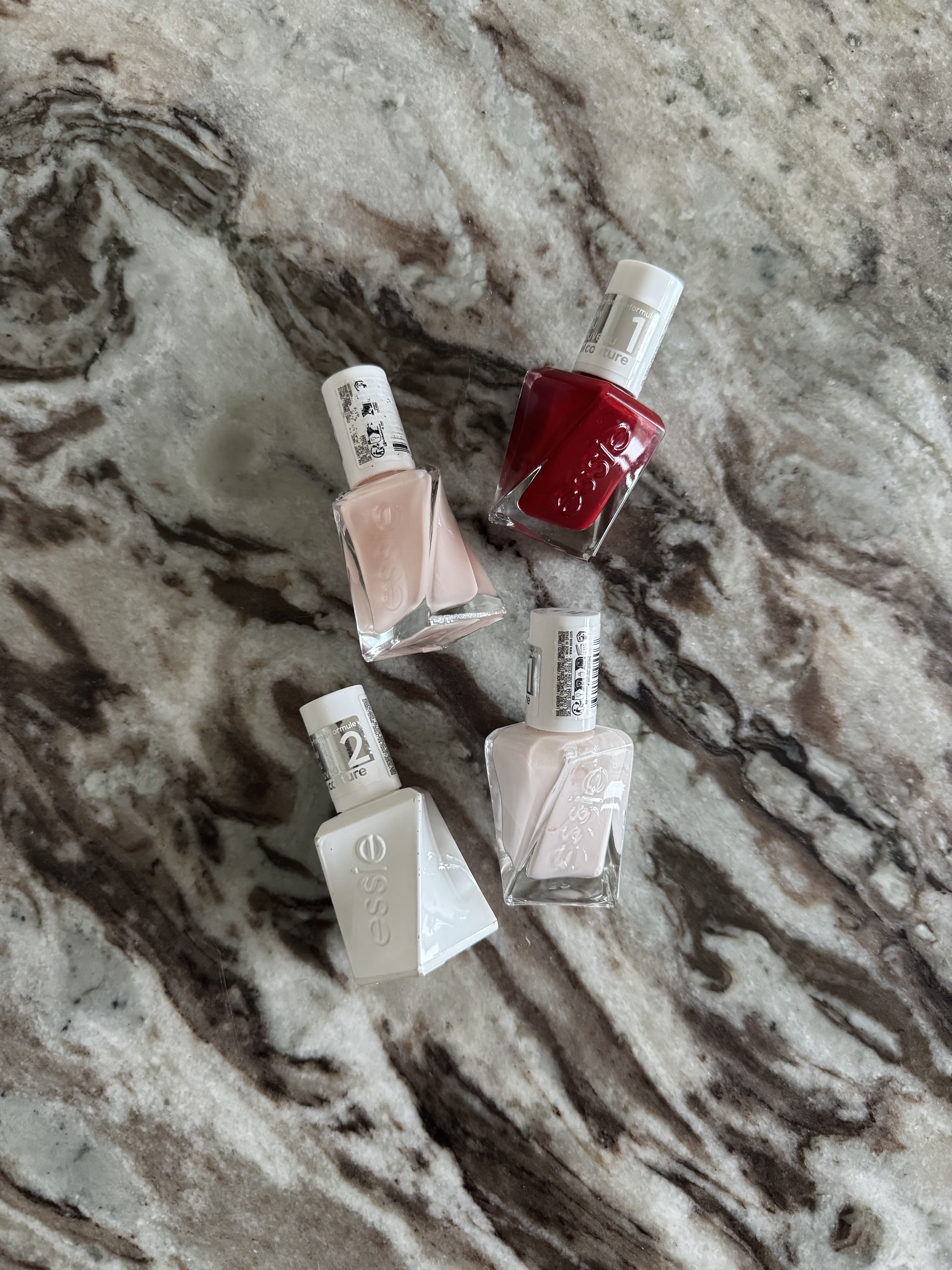 Essie gel couture nail polish bottles on a marble table