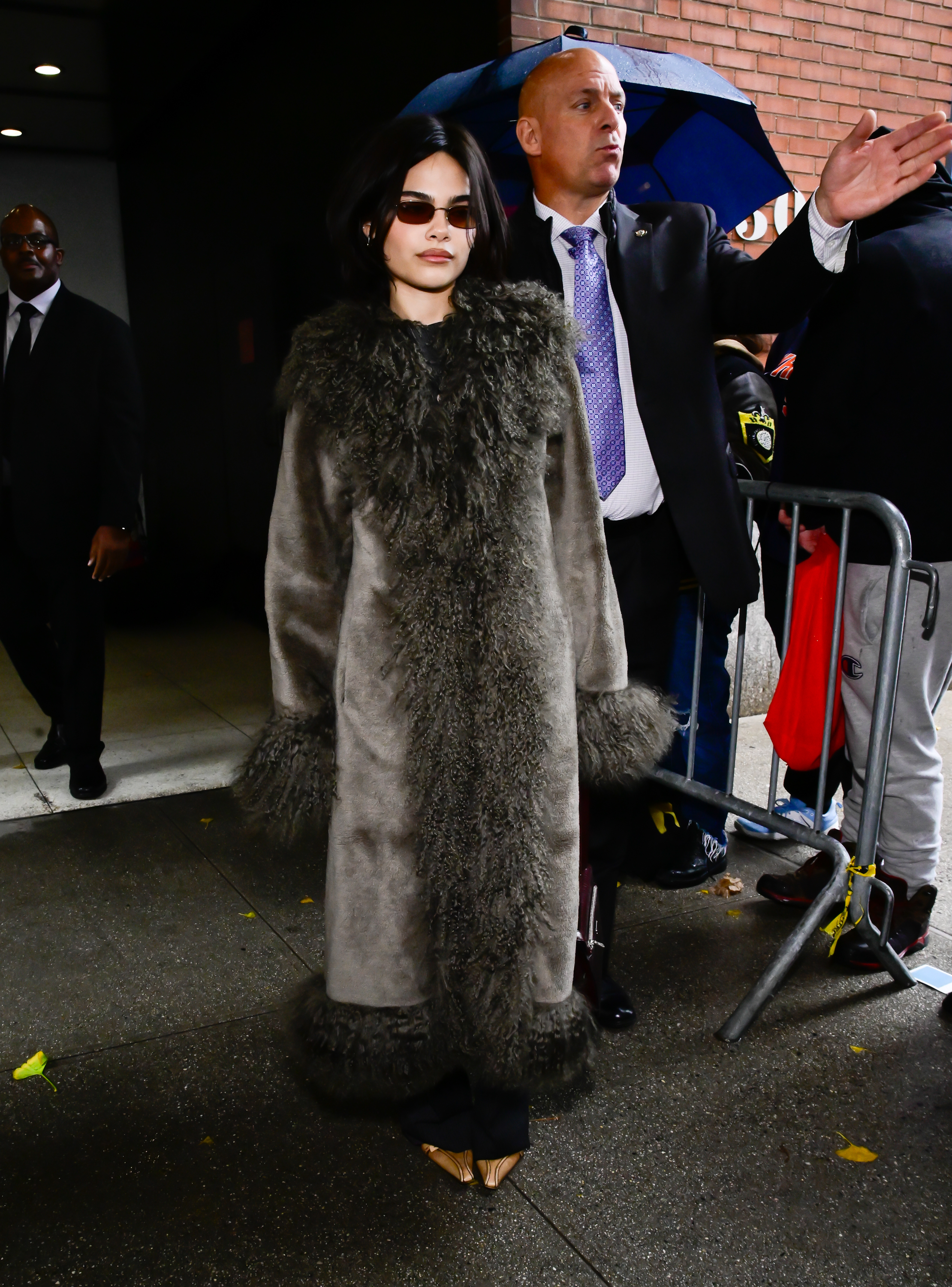 Ariana Greenblatt styles a fur-trim coat with pointed-toe shoes and black trousers.