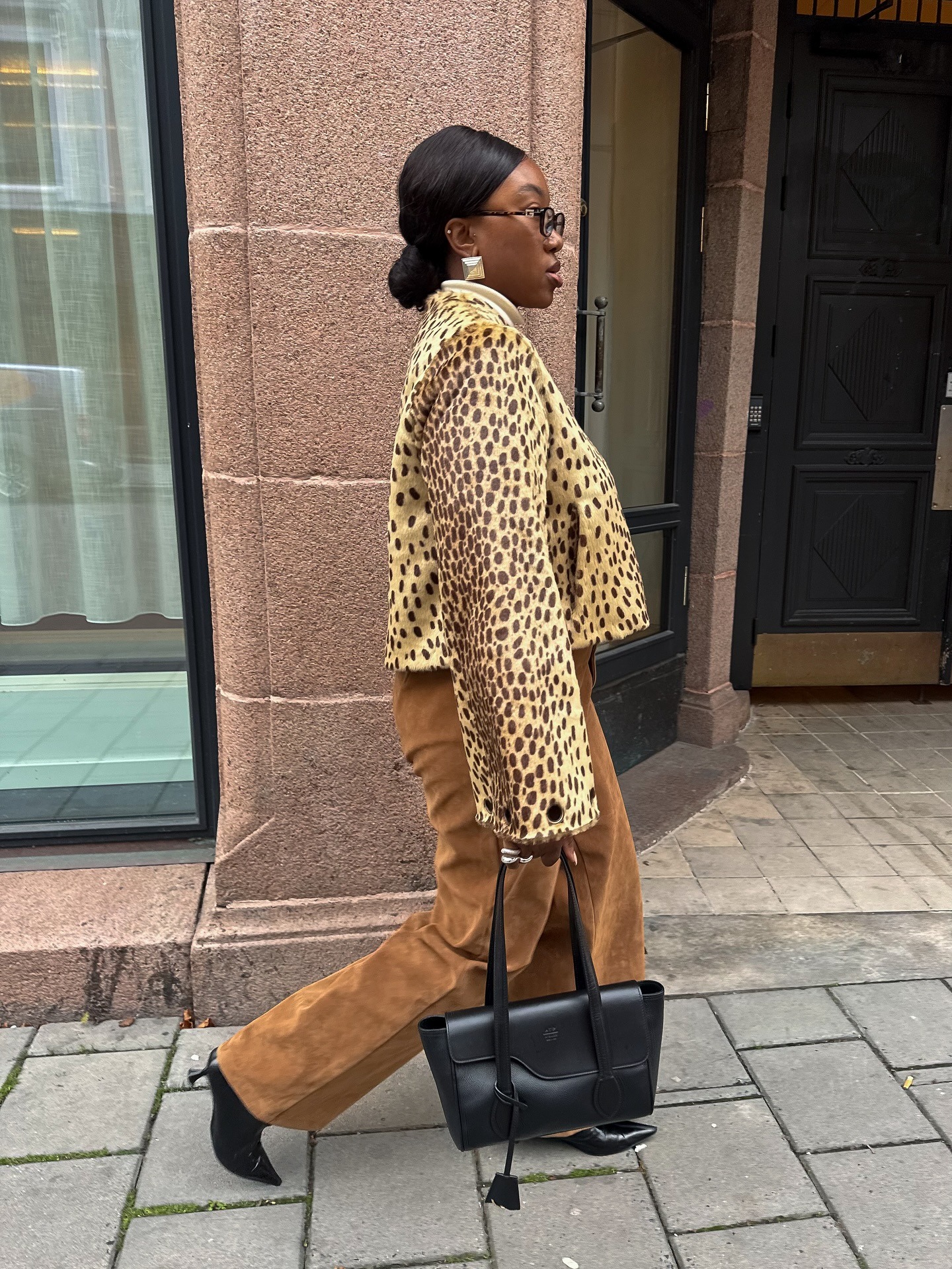 Influencer @nnennaechem wears a leopard print jacket with brown suede trousers and black kitten-heel boots.