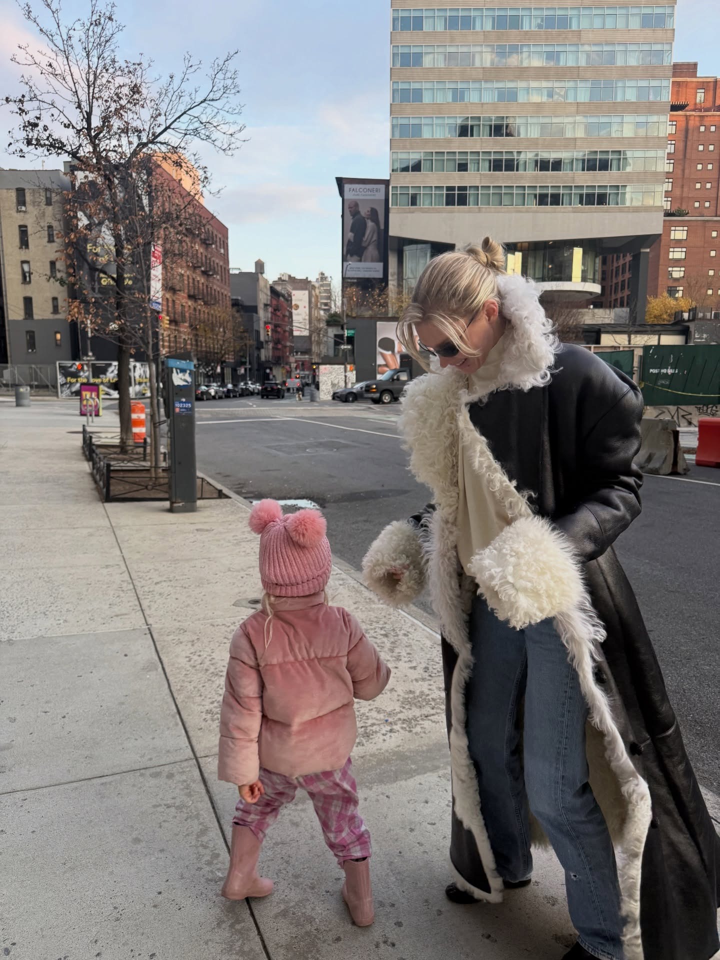 Elsa wears a leather Penny Lane coat with blue jeans.