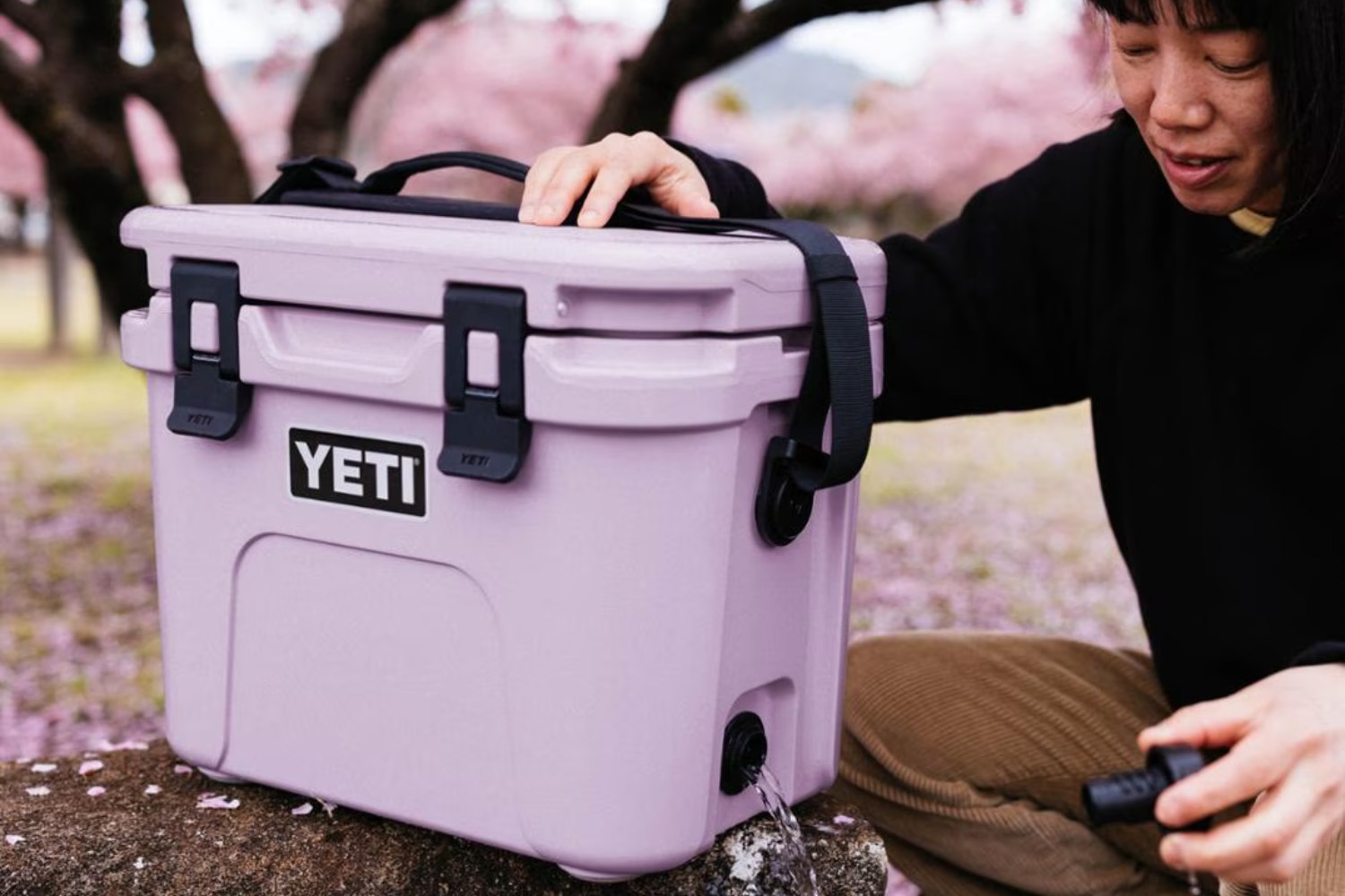 The Yeti Roadie 15 Cooler in pink outdoors.