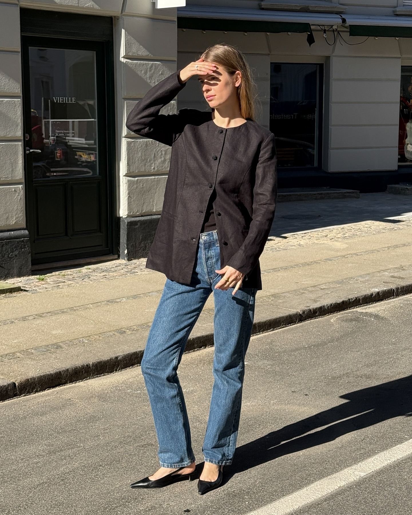 Influencer @claradyrhauge wears a collarless blazer with blue straight-leg jeans and closed-toe kitten heels.