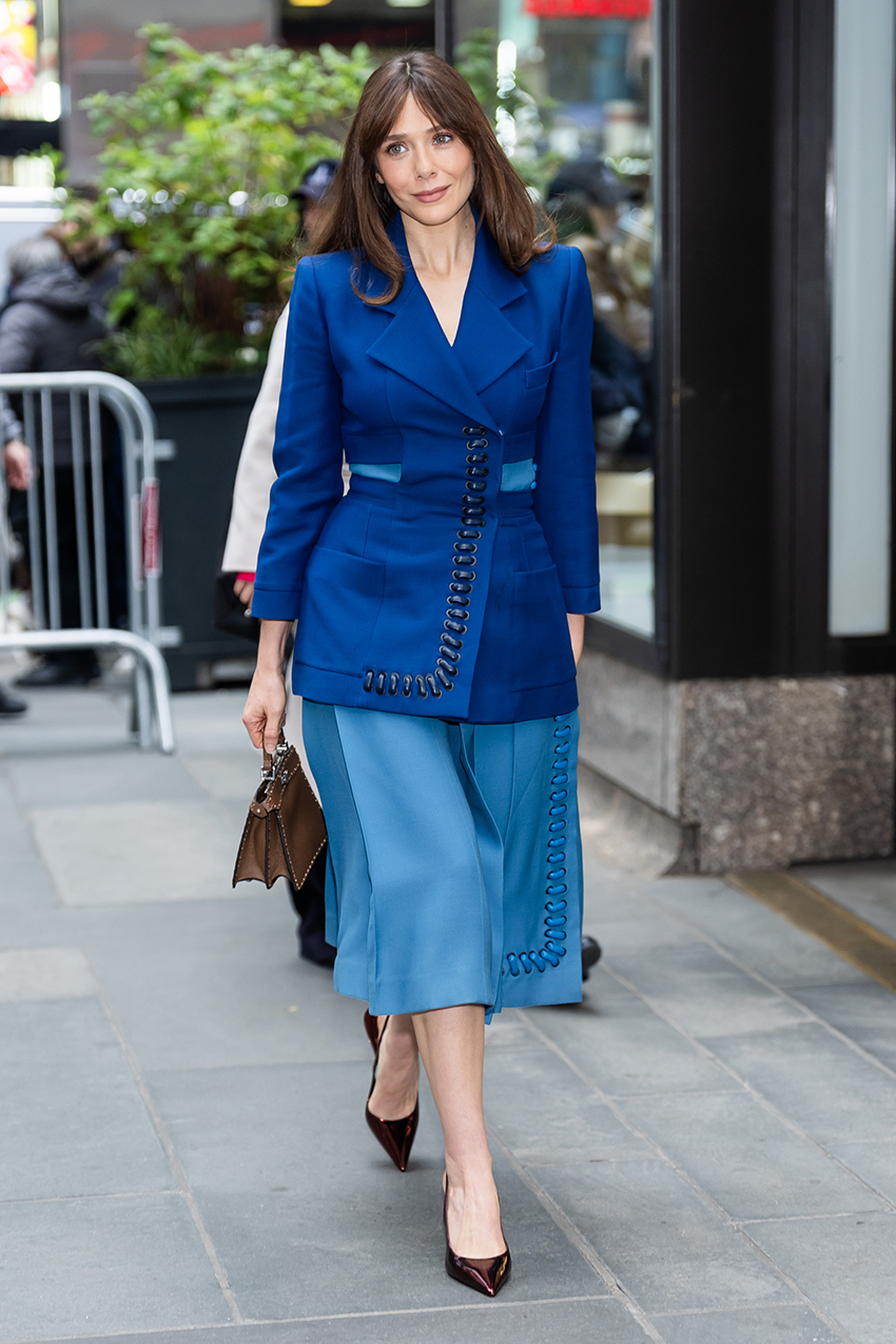 Elizabeth Olsen wearing a blue suit and burgundy pumps