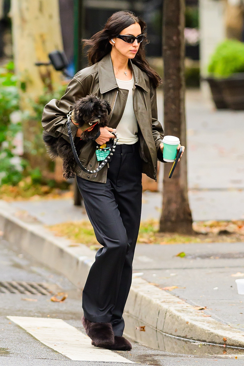 Irina Shayk wearing a leather bomber jacket, black trousers, and furry flat shoes in NYC
