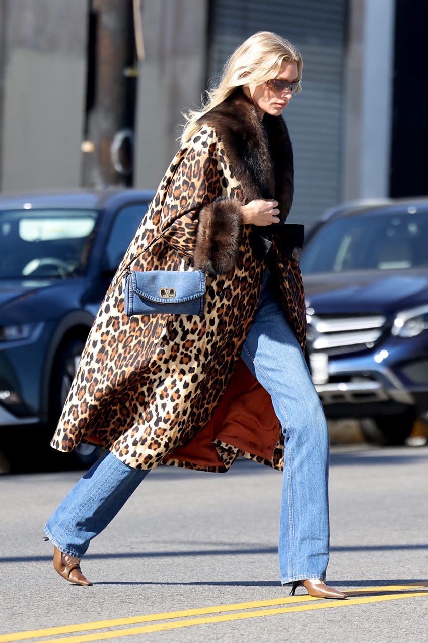 Elsa Hosk wearing a leopard coat, denim Valentino bag, jeans, and cognac pumps
