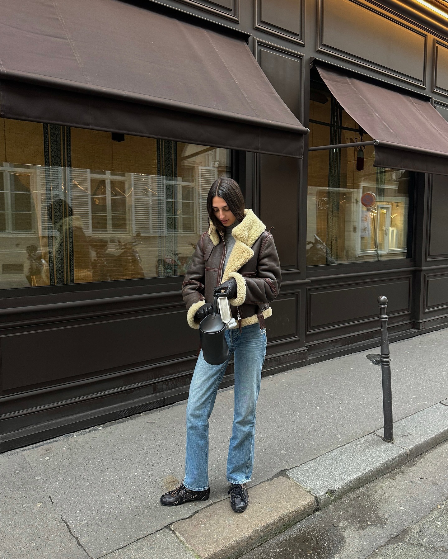 Influencer @salome.mory wears a sheepskin leather jacket with cigarette jeans a low-profile trainers.