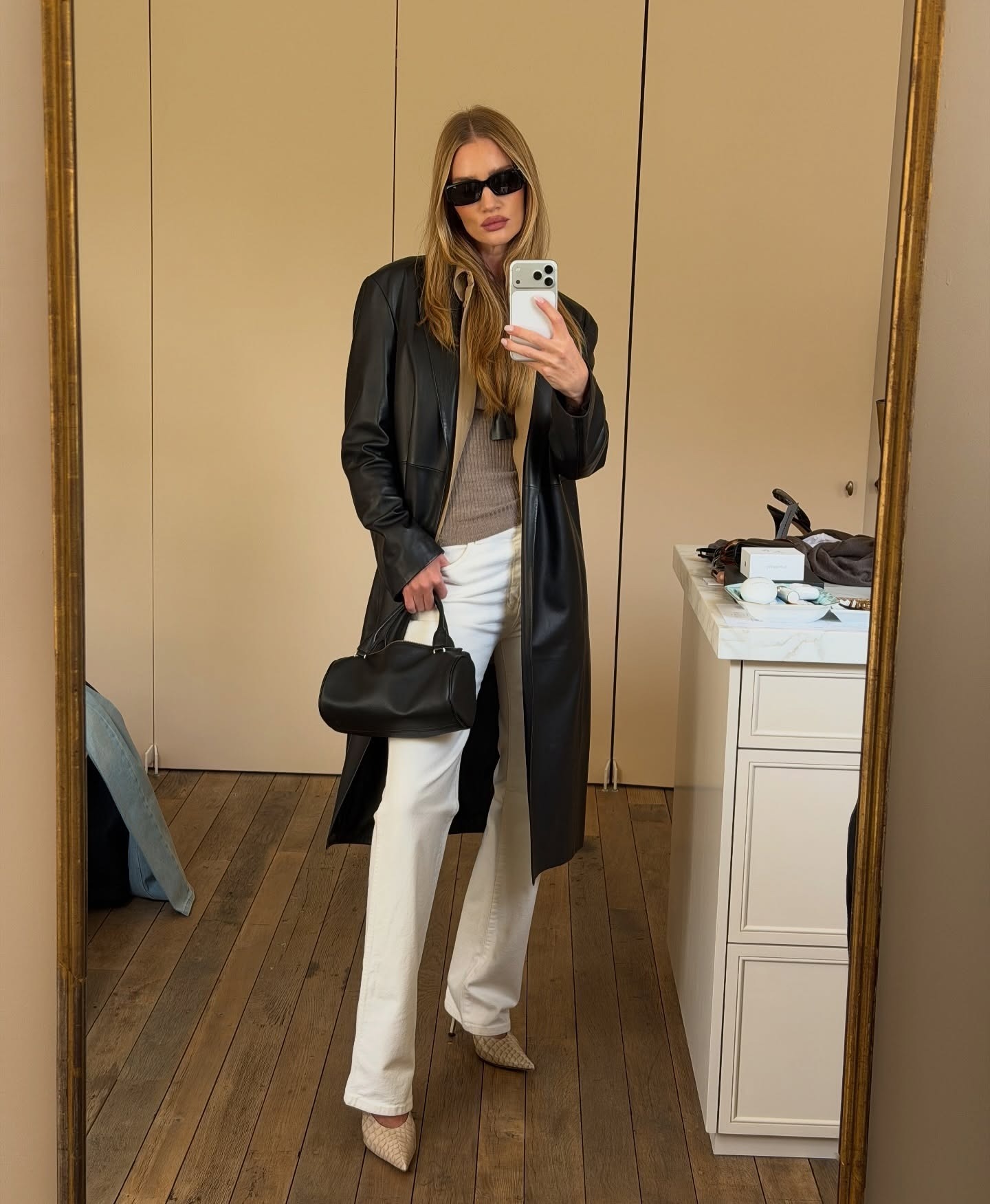 Rosie huntington-whiteley wears white jeans and a black leather jacket.