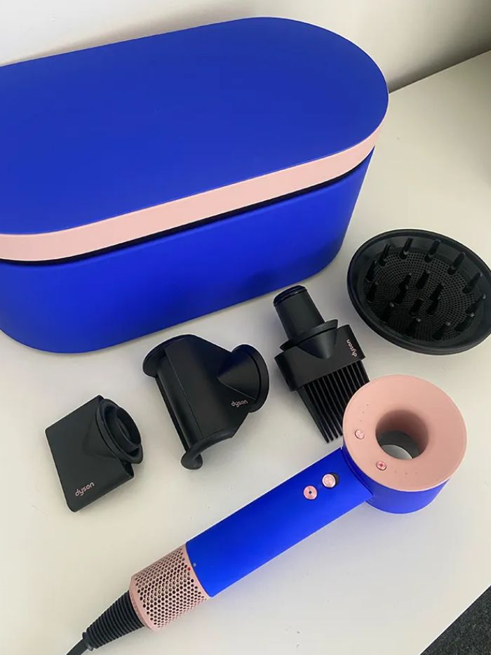 The blue Dyson hair dryer on a white background