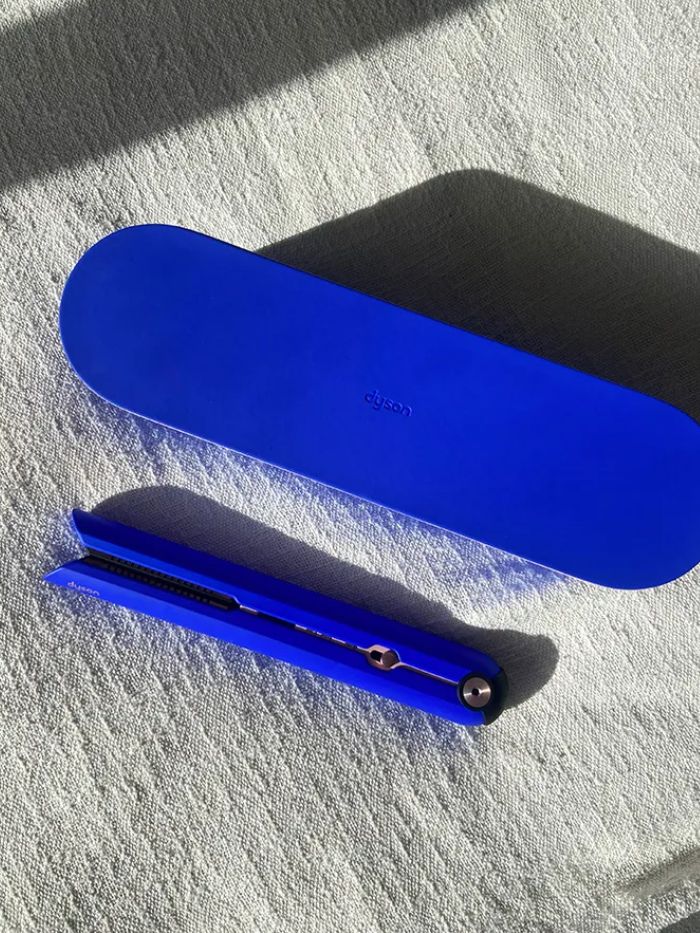 The blue Dyson Corrale on a white linen background