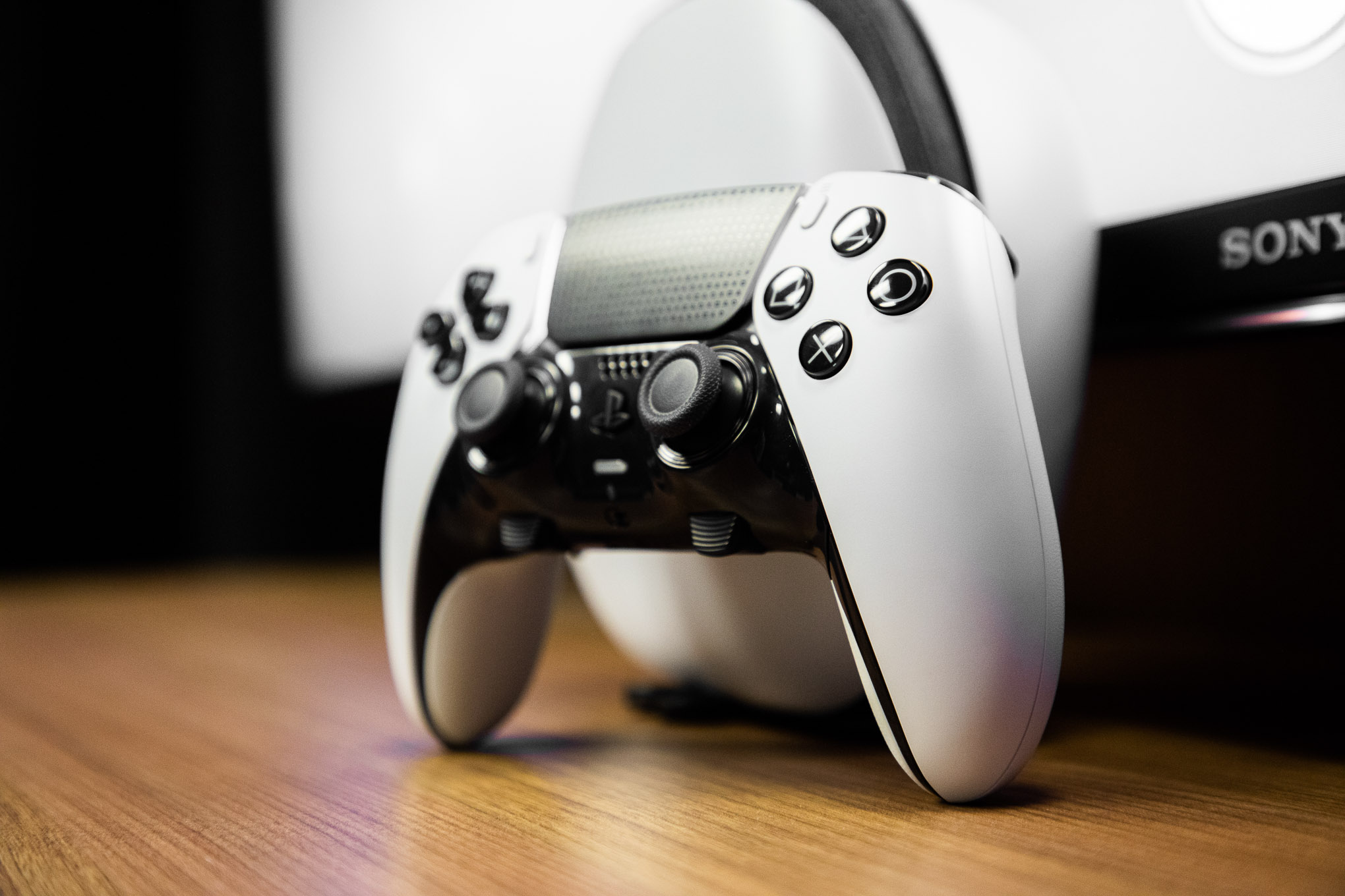 controller standing on a wooden table, wood grain running towards the camera at a slight angle