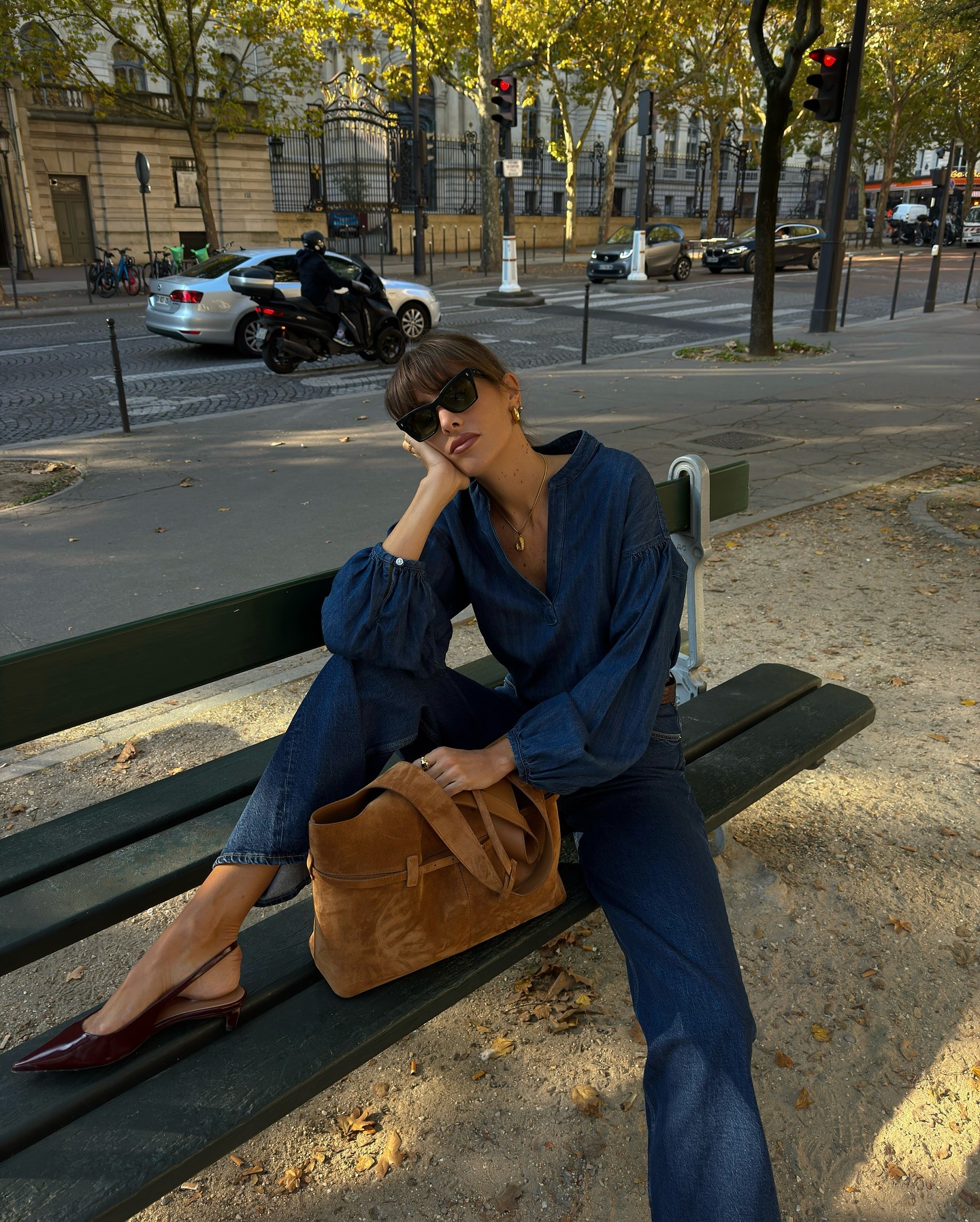 Influencer @juliesfi wears a denim jumpsuit with burgundy slingback heels.