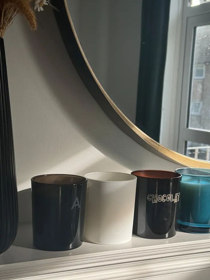 A picture of Beauty Pie candles on top of a fireplace