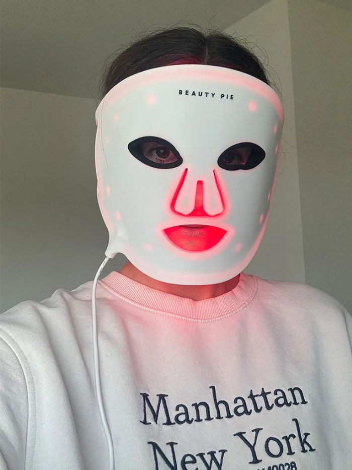 Beauty editor Eleanor Vousden wearing a Beauty Pie LED mask