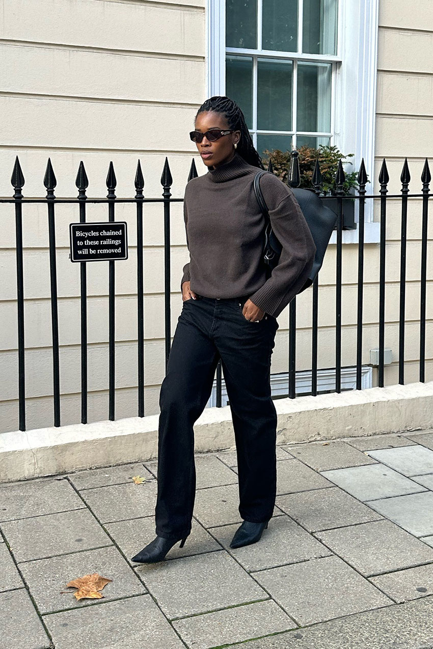 a woman wearing brown sweater, black pants, and black boots