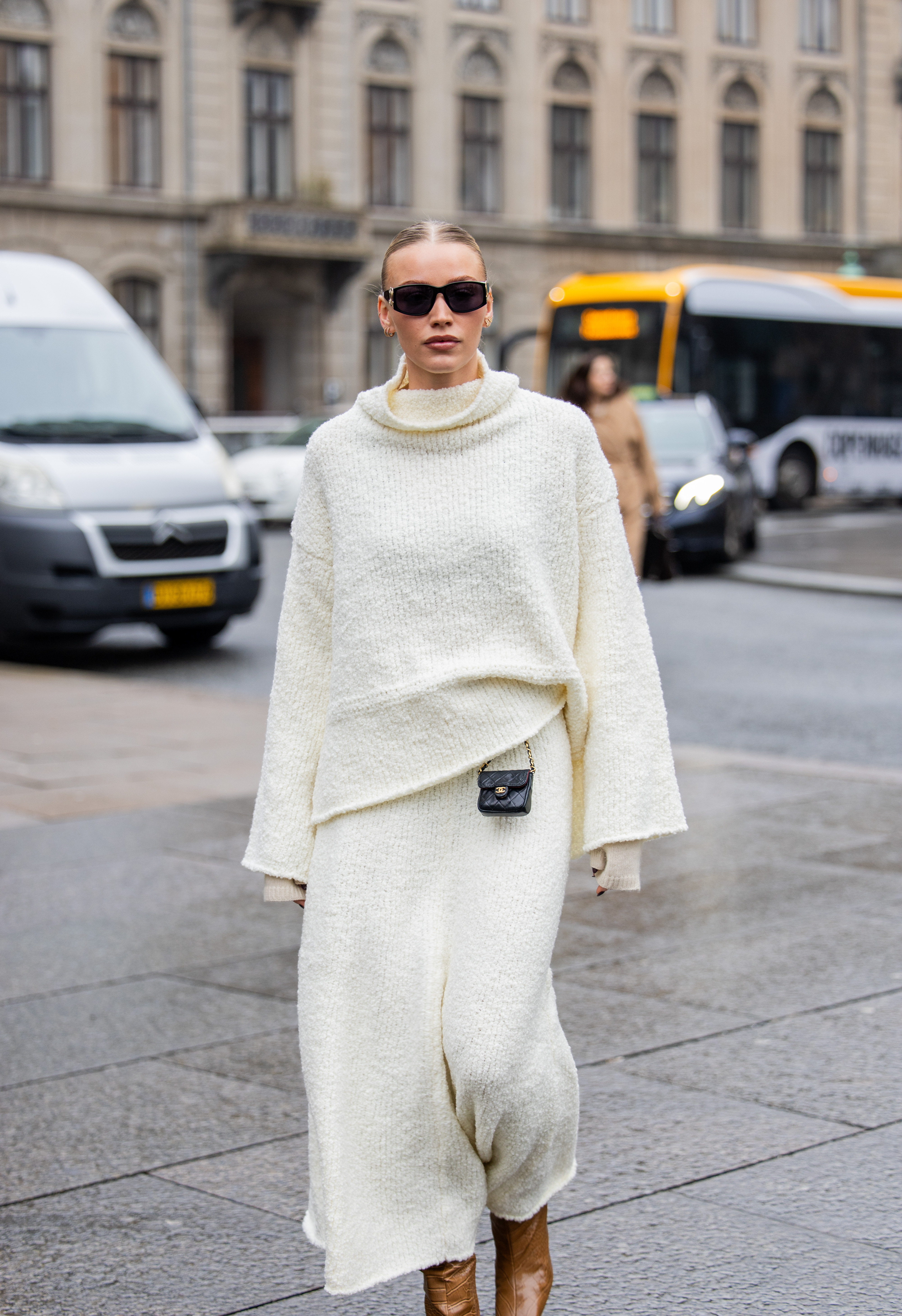 COPENHAGEN, DENMARK - JANUARY 30: Sophie Sunde Sylte wears micro Chanel bag, creme white knit with wide sleeves, skirt, brown boots, Chanel sunglasses outside Aeron during the Copenhagen Fashion Week AW24 on January 30, 2024 in Copenhagen, Denmark. (Photo by Christian Vierig/Getty Images)