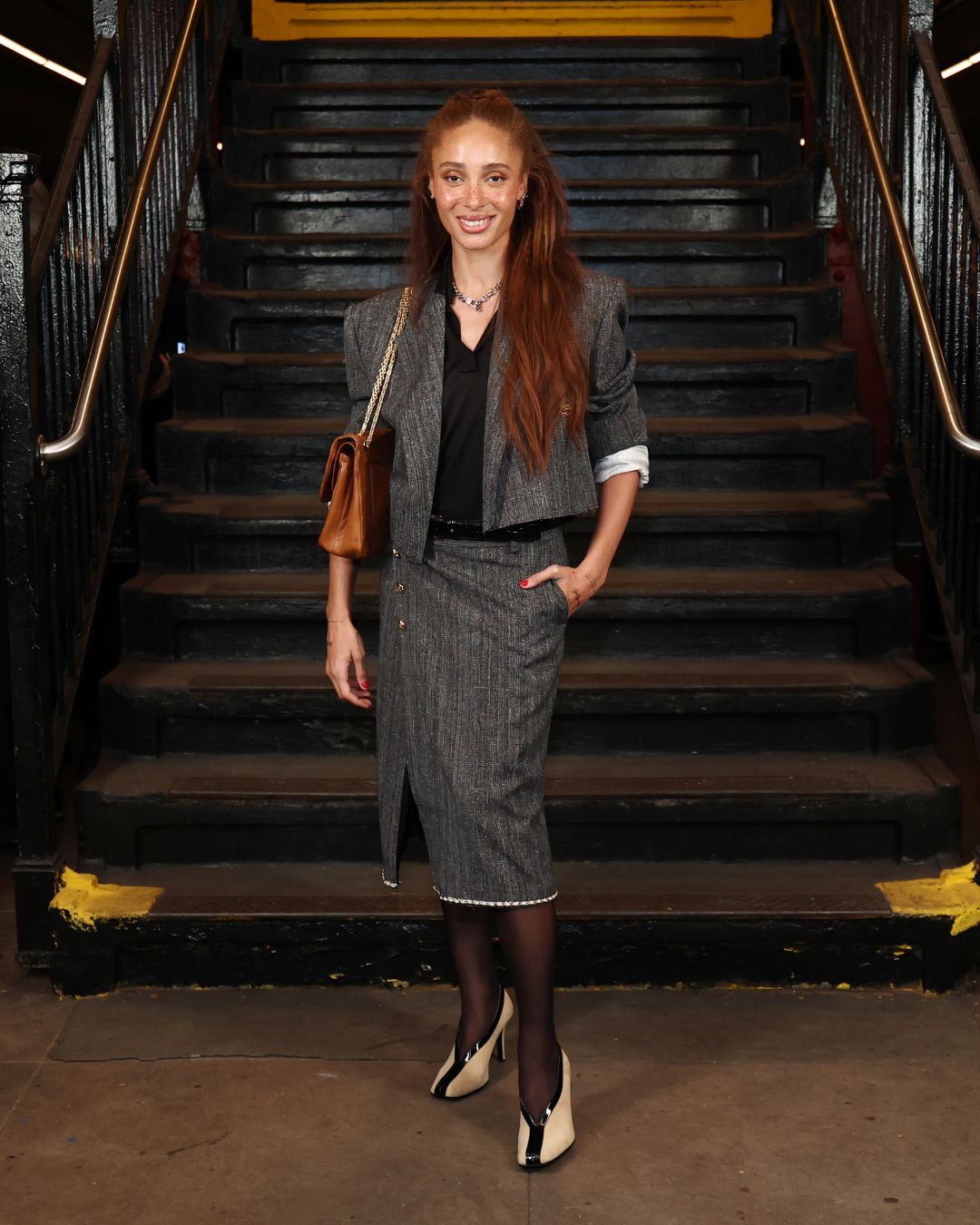 Adwoa Aboah wears a grey pencil skirt with a grey cropped blazer and high-vamp heels at Chanel&#039;s M&amp;eacute;tiers d&#039;art Show in New York