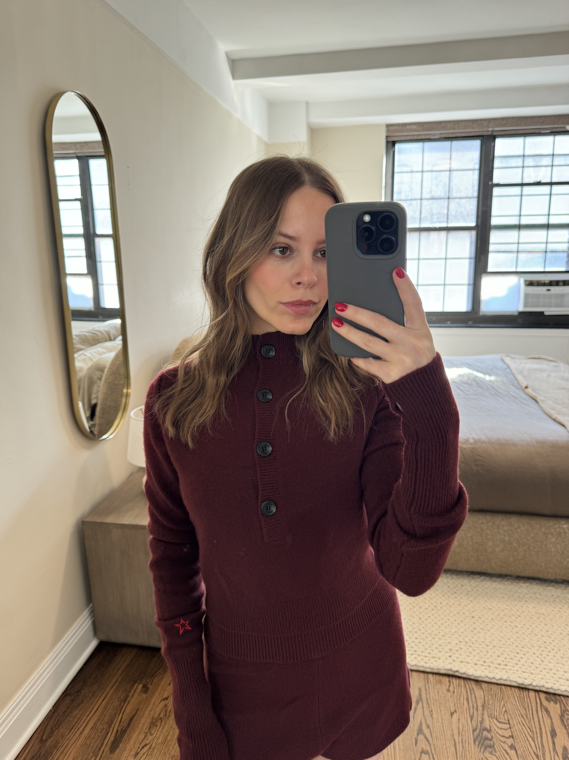 Nikki tries on a burgundy button down sweater and shorts.