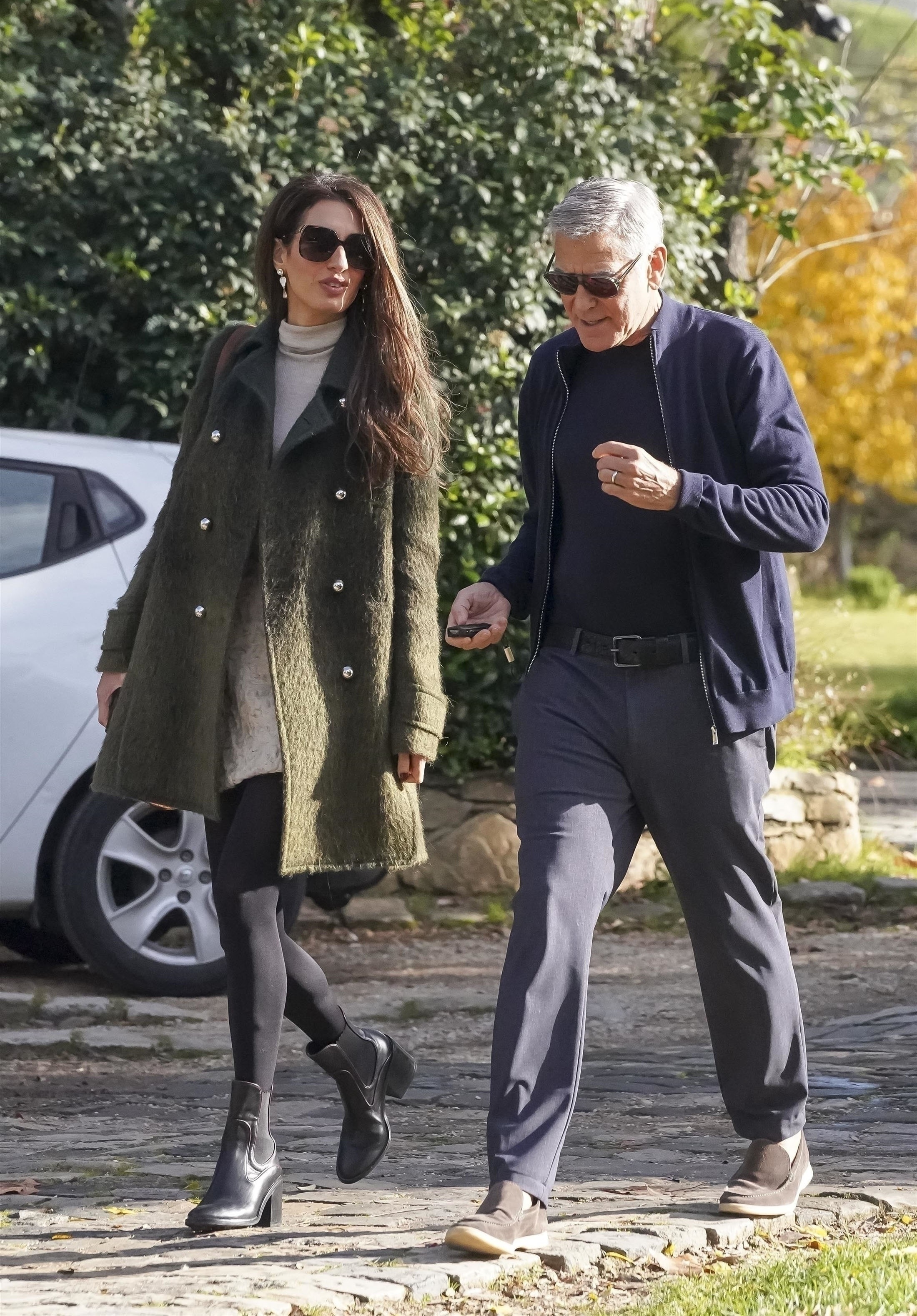 Amal Clooney wears a moss green coat with black tights and boots in Provence, France, for a lunch date with George Clooney