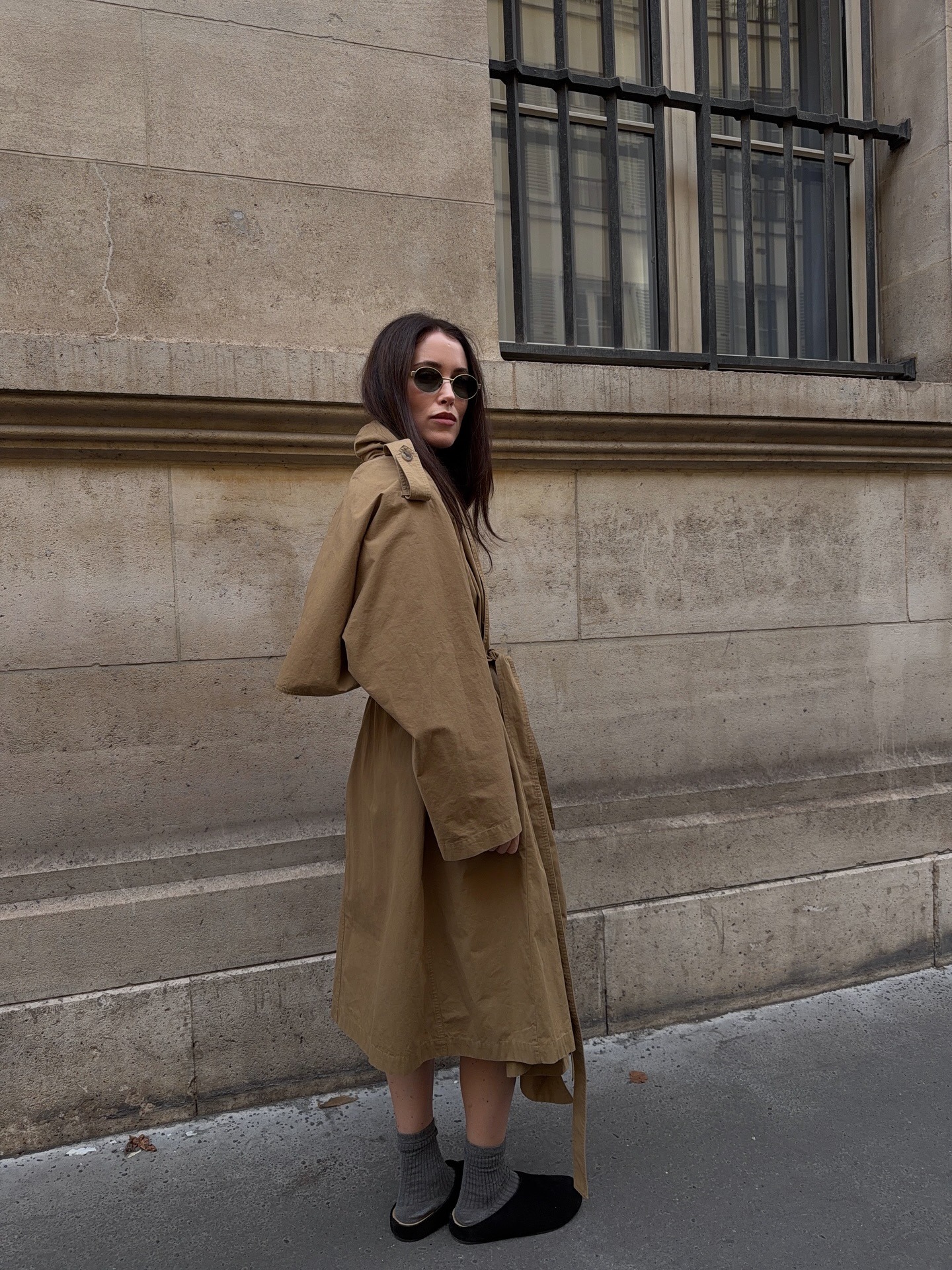 Influencer wearing a trench, socks, and flat suede mules