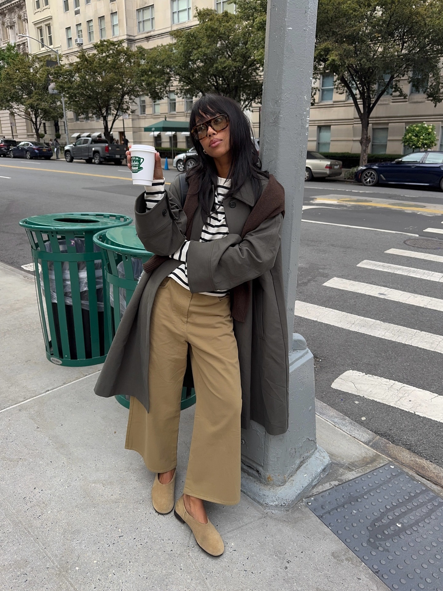 Influencer wearing a trench, khaki pants, and flats