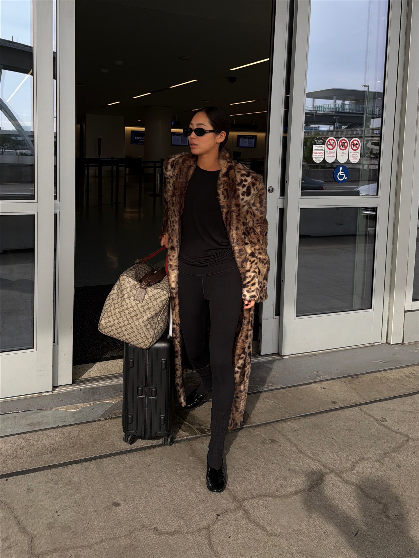 Aimee Song wearing a leopard coat, leggings, and flats