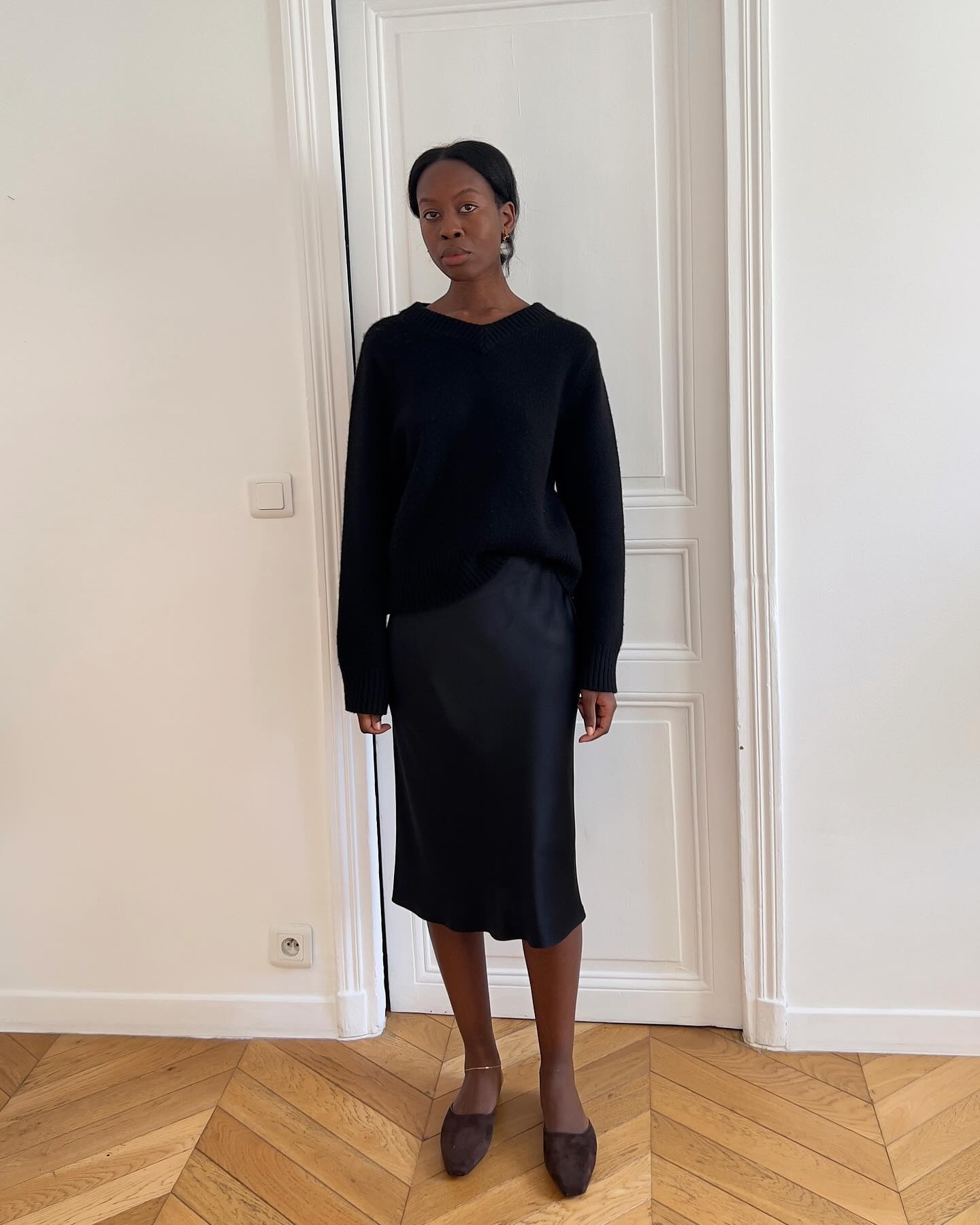 Influencer wearing a sweater, slip skirt, and suede mules