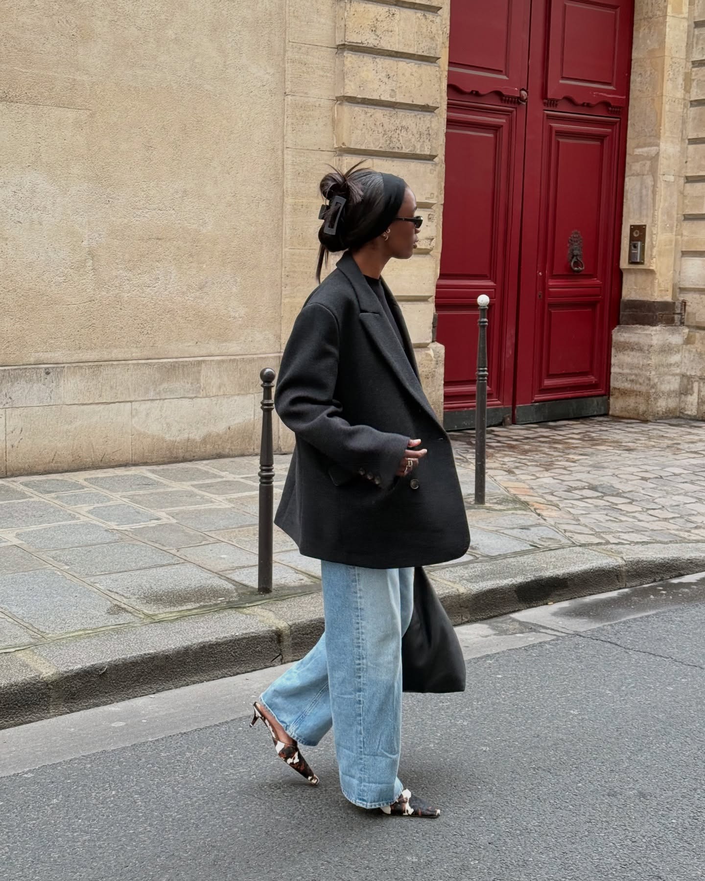 @_livmadeline wears cow-print calf-shoes with blue baggy jeans, an oversized blazer, and a black tote.