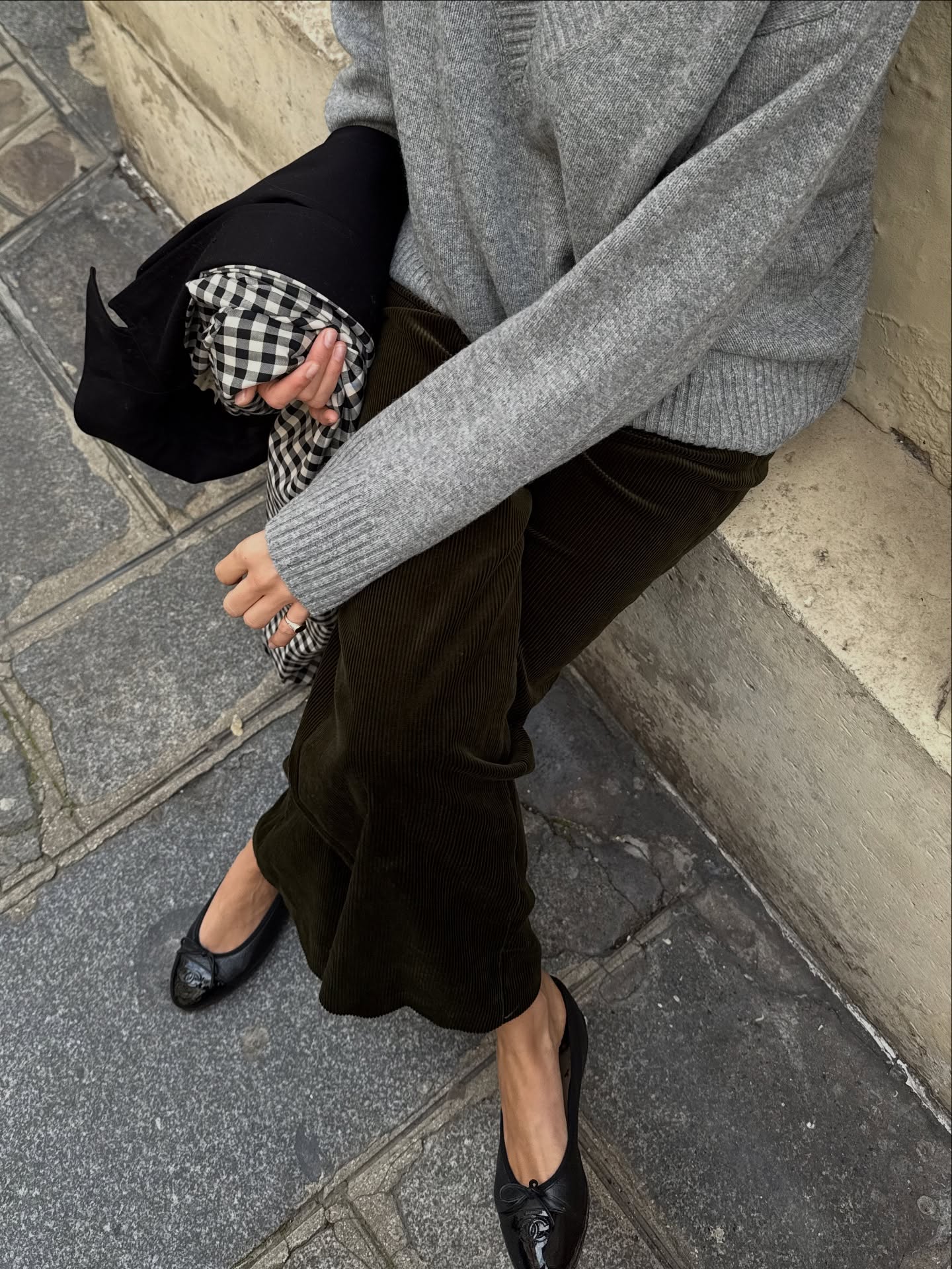 An image of @lizzyhadfield wearing flocked fabrics, one of 2026 biggest jean trends, with a light grey woollen jumper and round toe ballet flats.