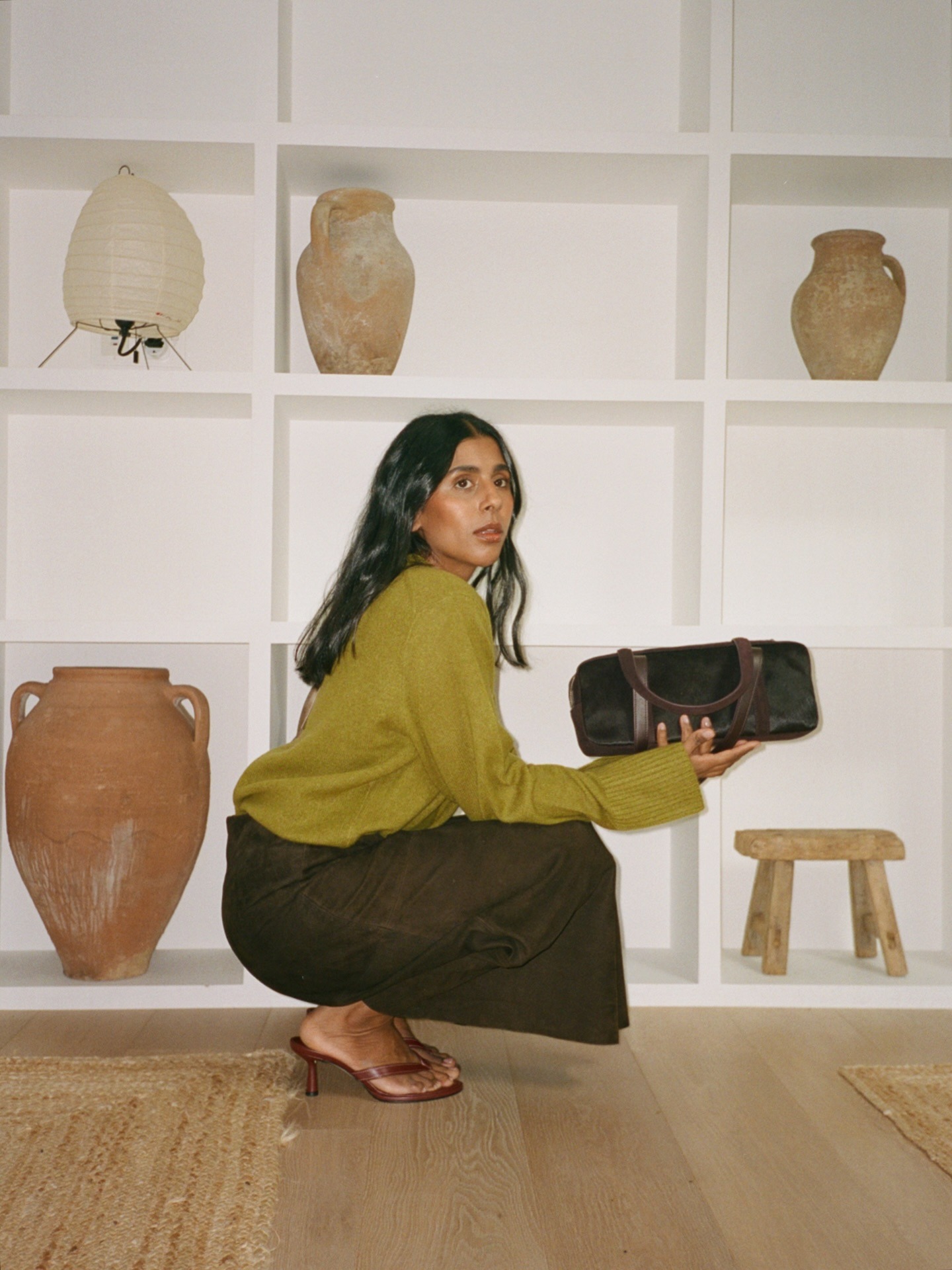 Influencer @monikh wears a brown suede skirt with brown heeled flip-flops.