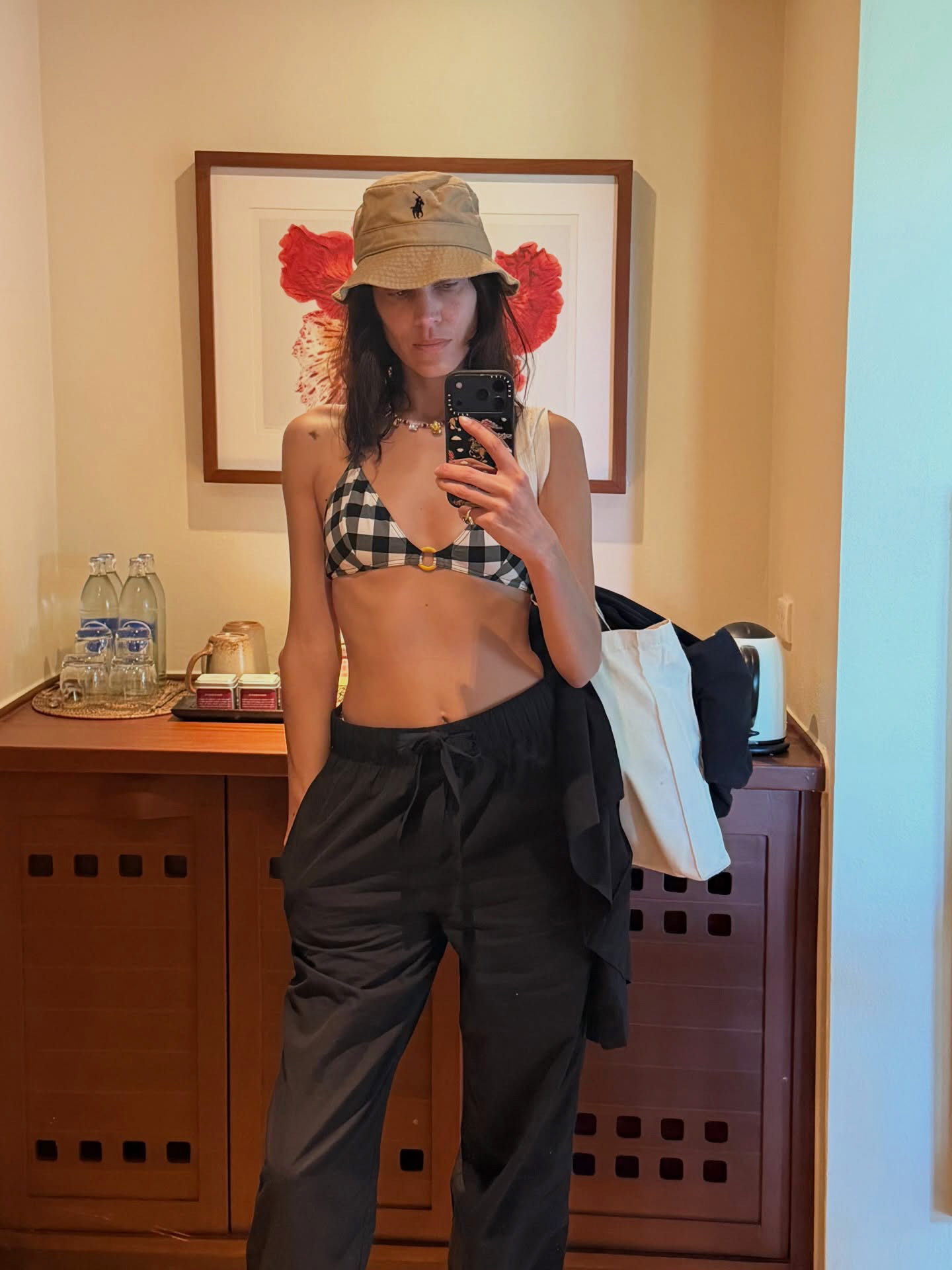 Alexa Chung wearing a Polo Ralph Lauren Cotton Chino Bucket Hat, gingham bikini, and black pull-on pants.